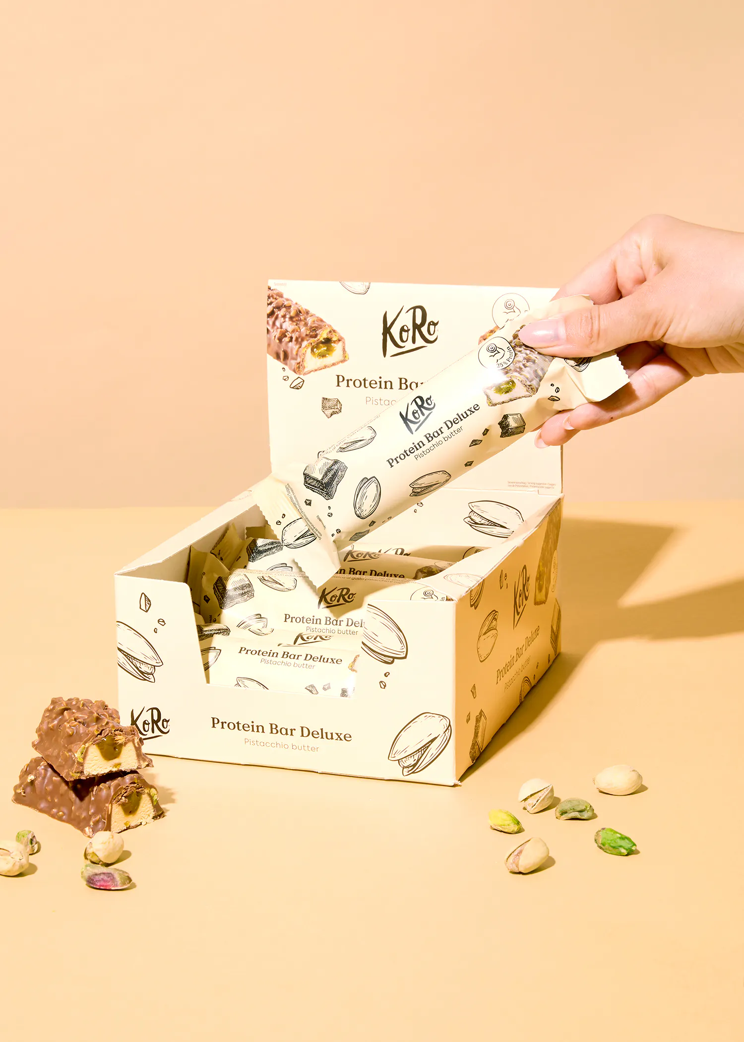 eine hand hält einen protein bar deluxe aus einer box
