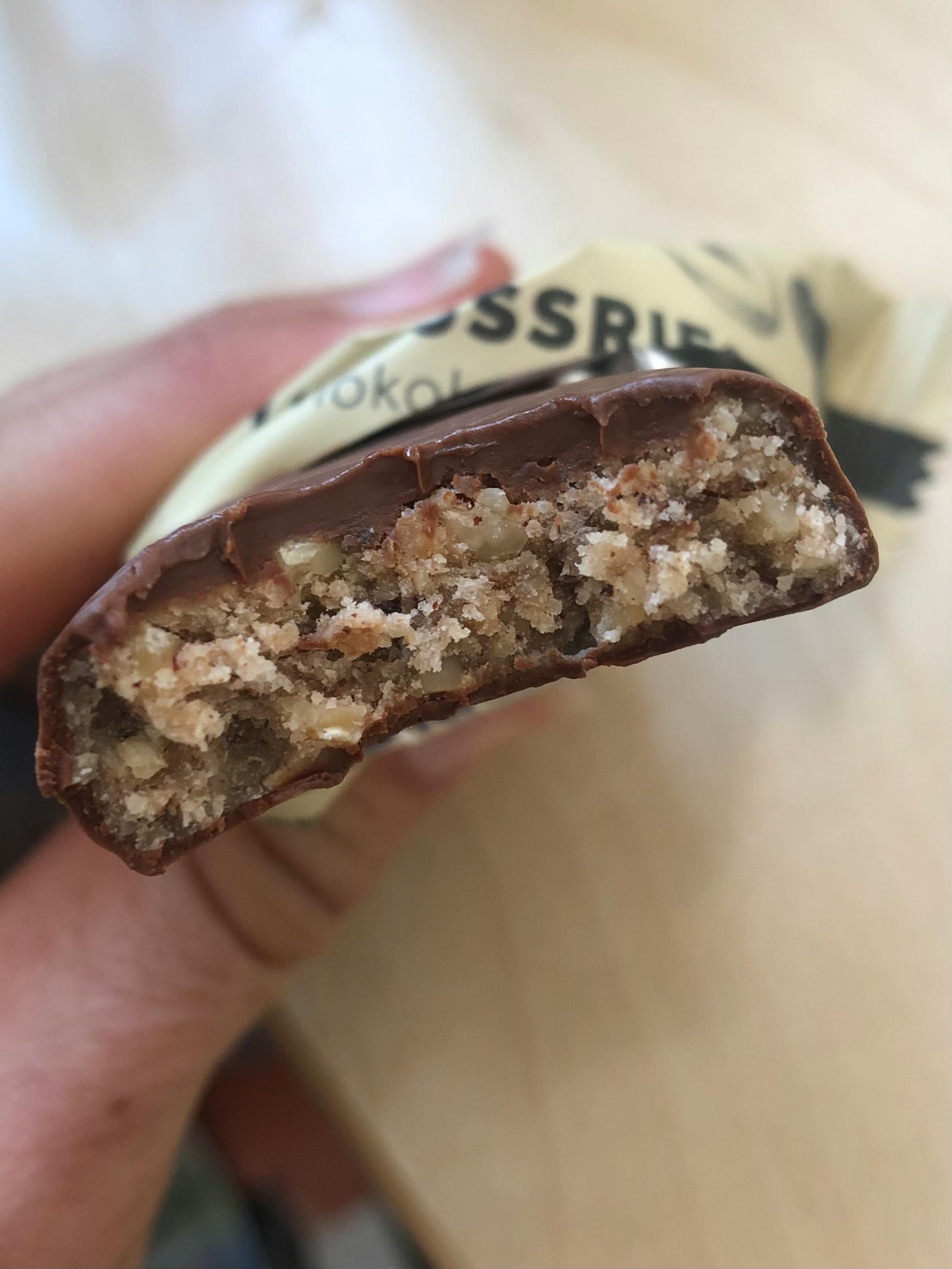 une personne tient une barre de chocolat avec un morceau coupé en deux