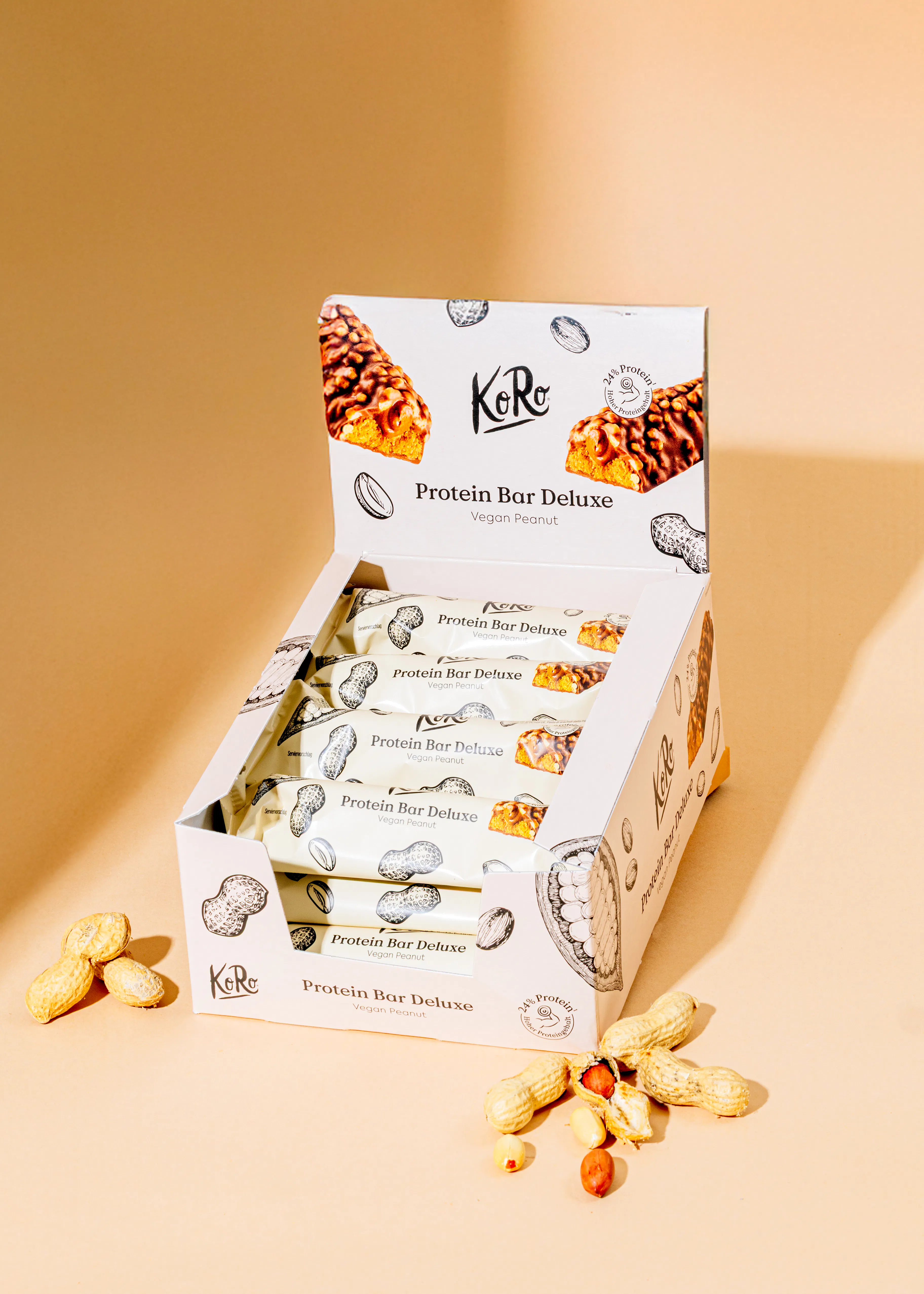 una caja de barras de proteínas deluxe con cacahuetes alrededor