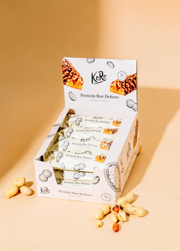 una caja de barras de proteínas deluxe con cacahuetes alrededor