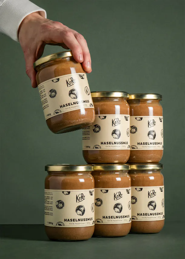 a person is holding a jar of haselnussmus