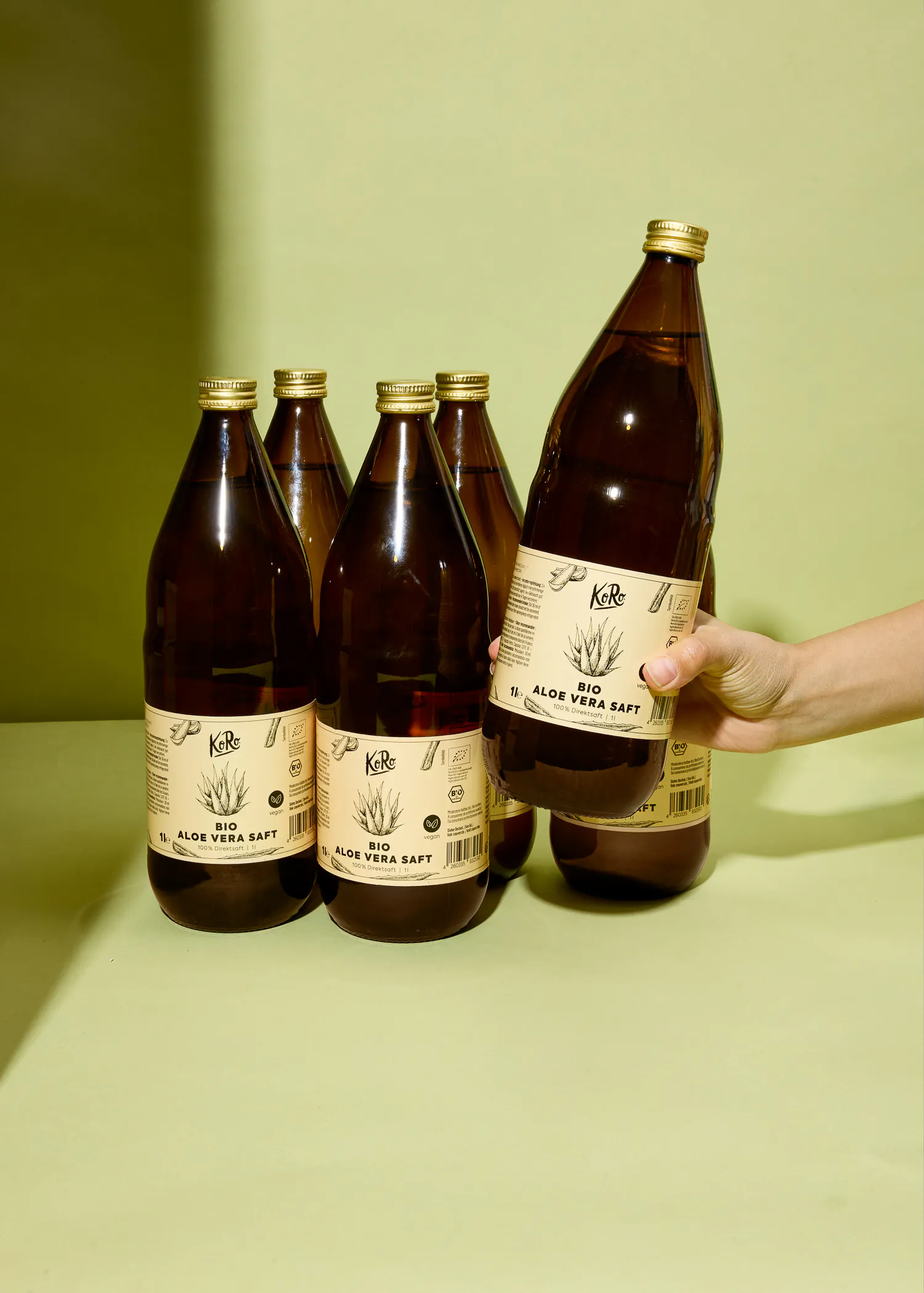 eine Person hält eine Flasche aloe verasaft in der Hand