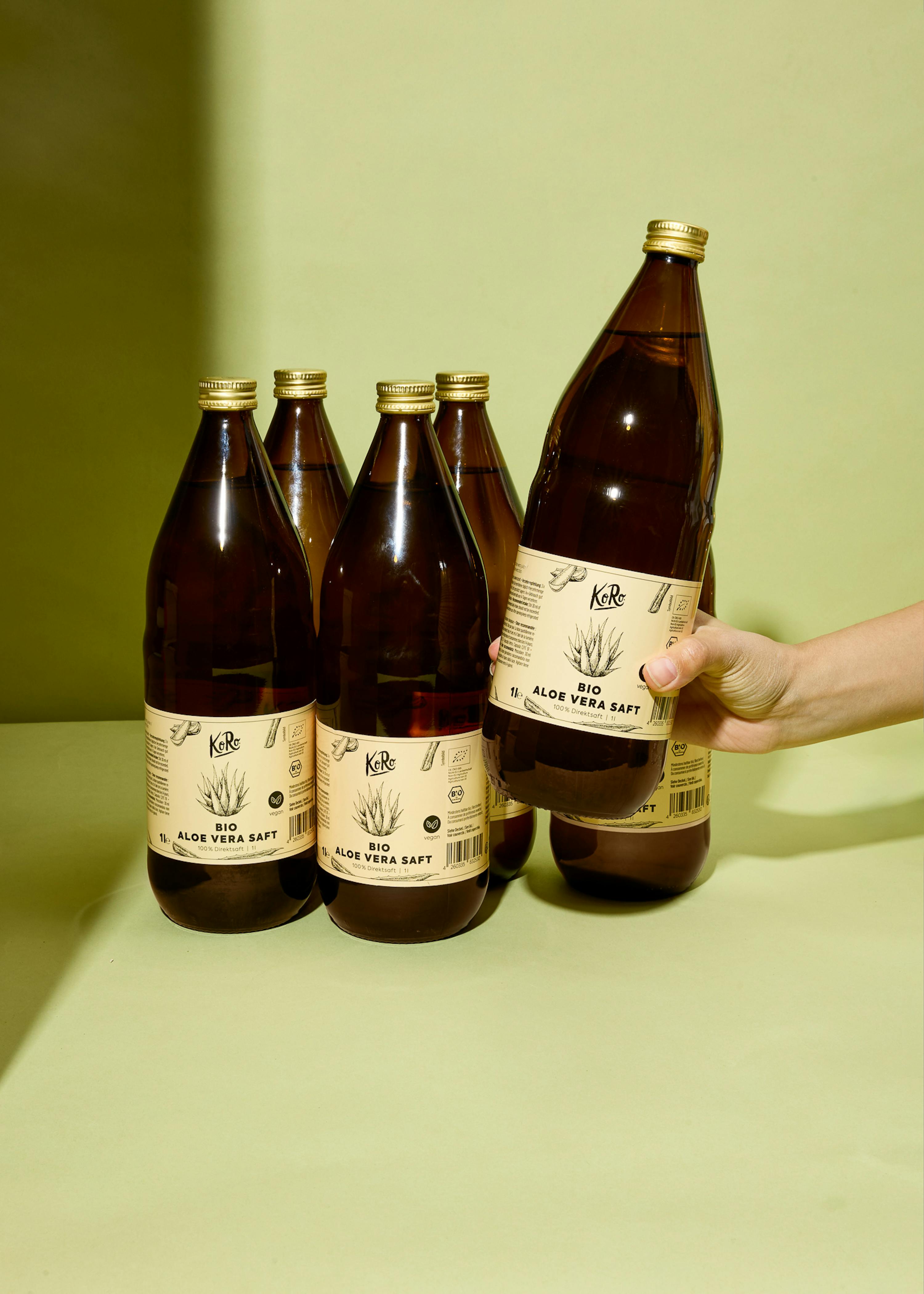 a hand holds a bottle of aloe vera soft