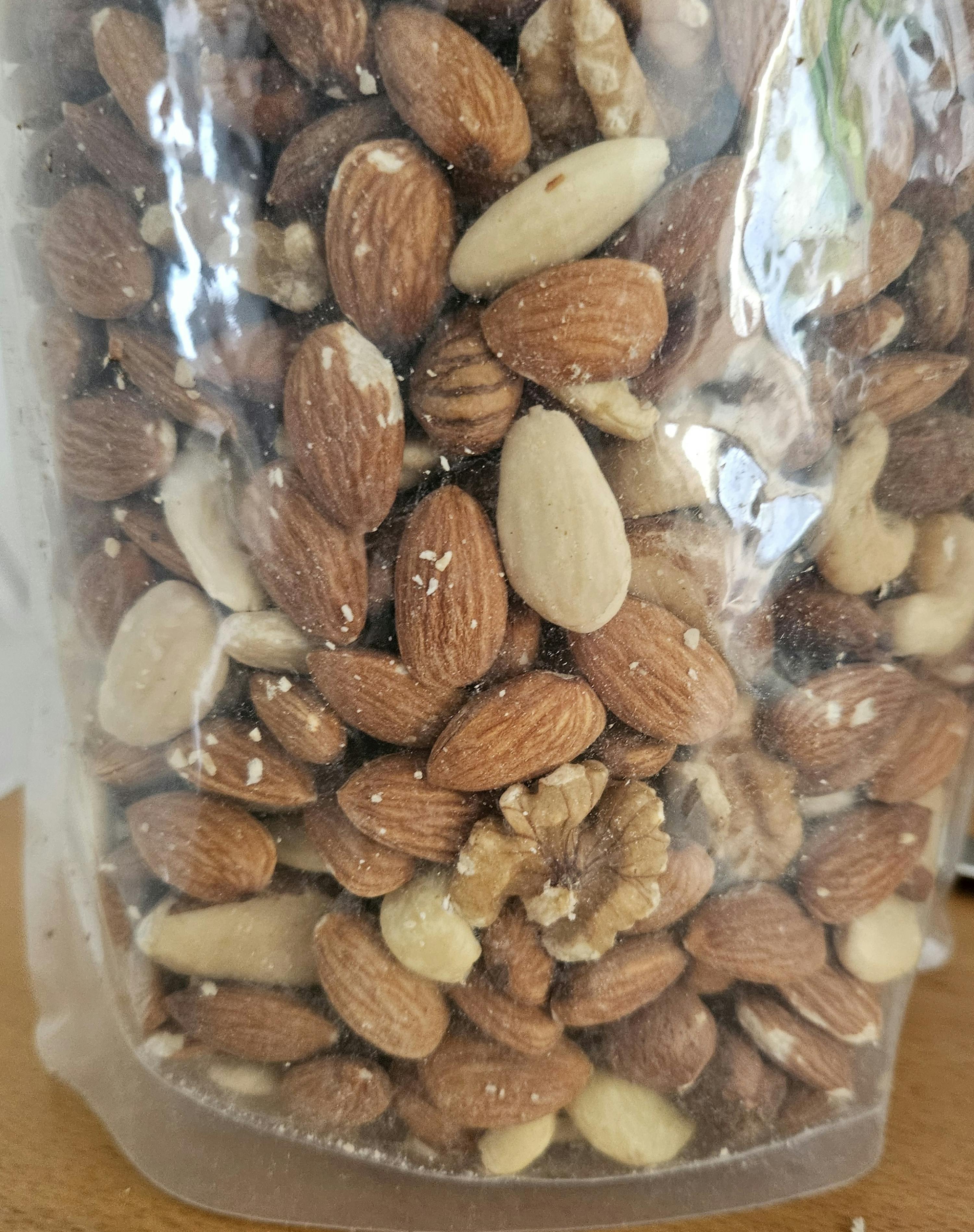 un sac en plastique rempli d' amandes et de noix