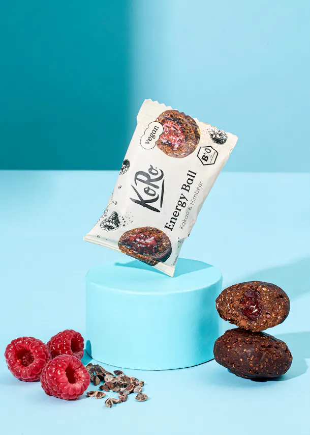 eine verpackte energy-ball liegt auf einem blauen podium