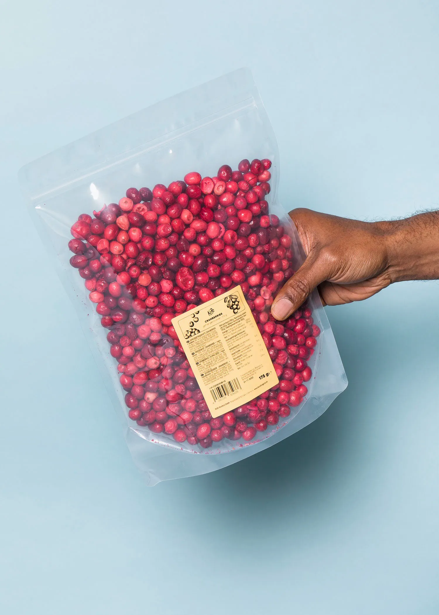 a person holding a bag of cranberries with a label on it