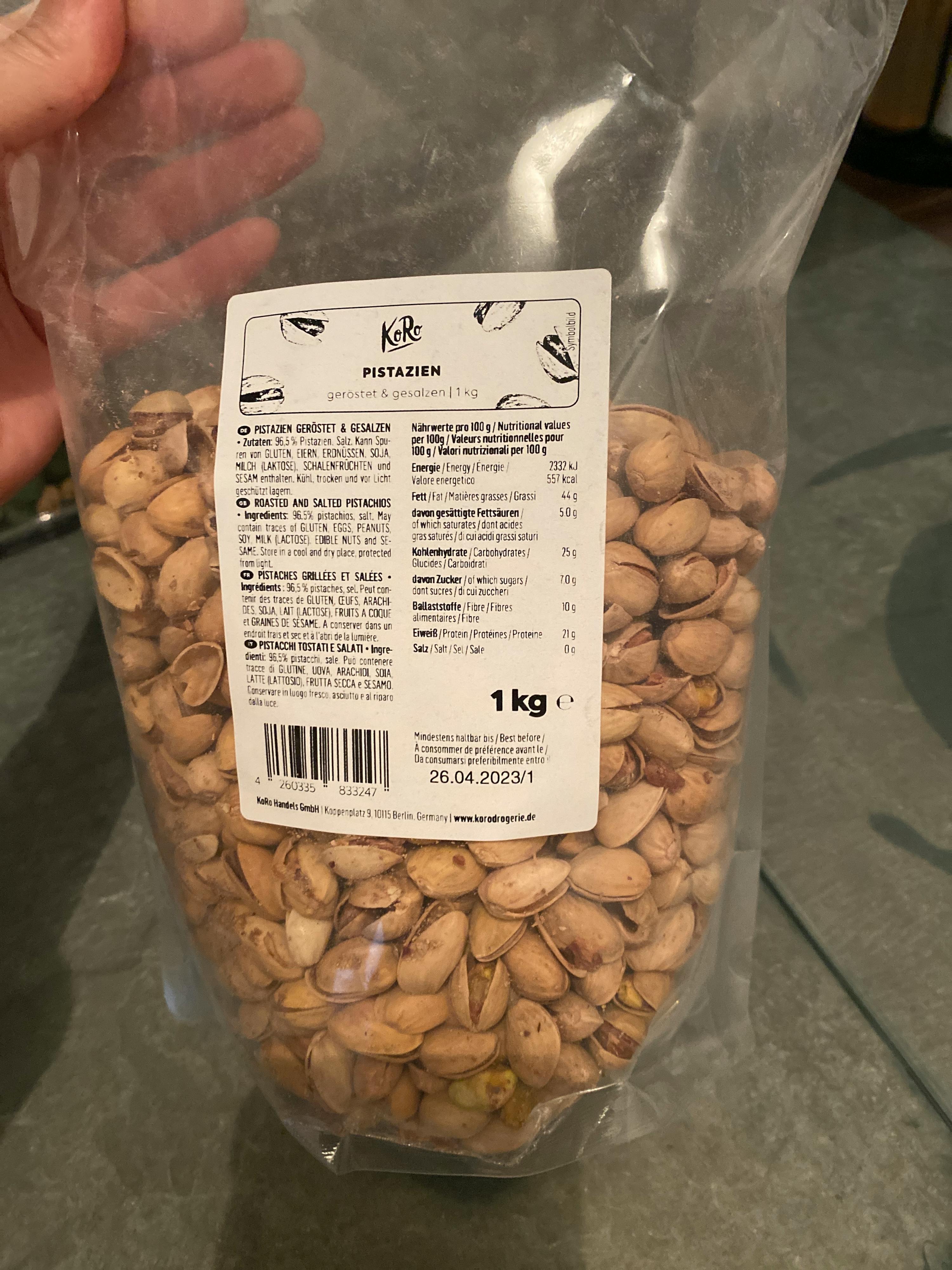 eine Person hält einen Plastikbeutel mit pistazien in der Hand
