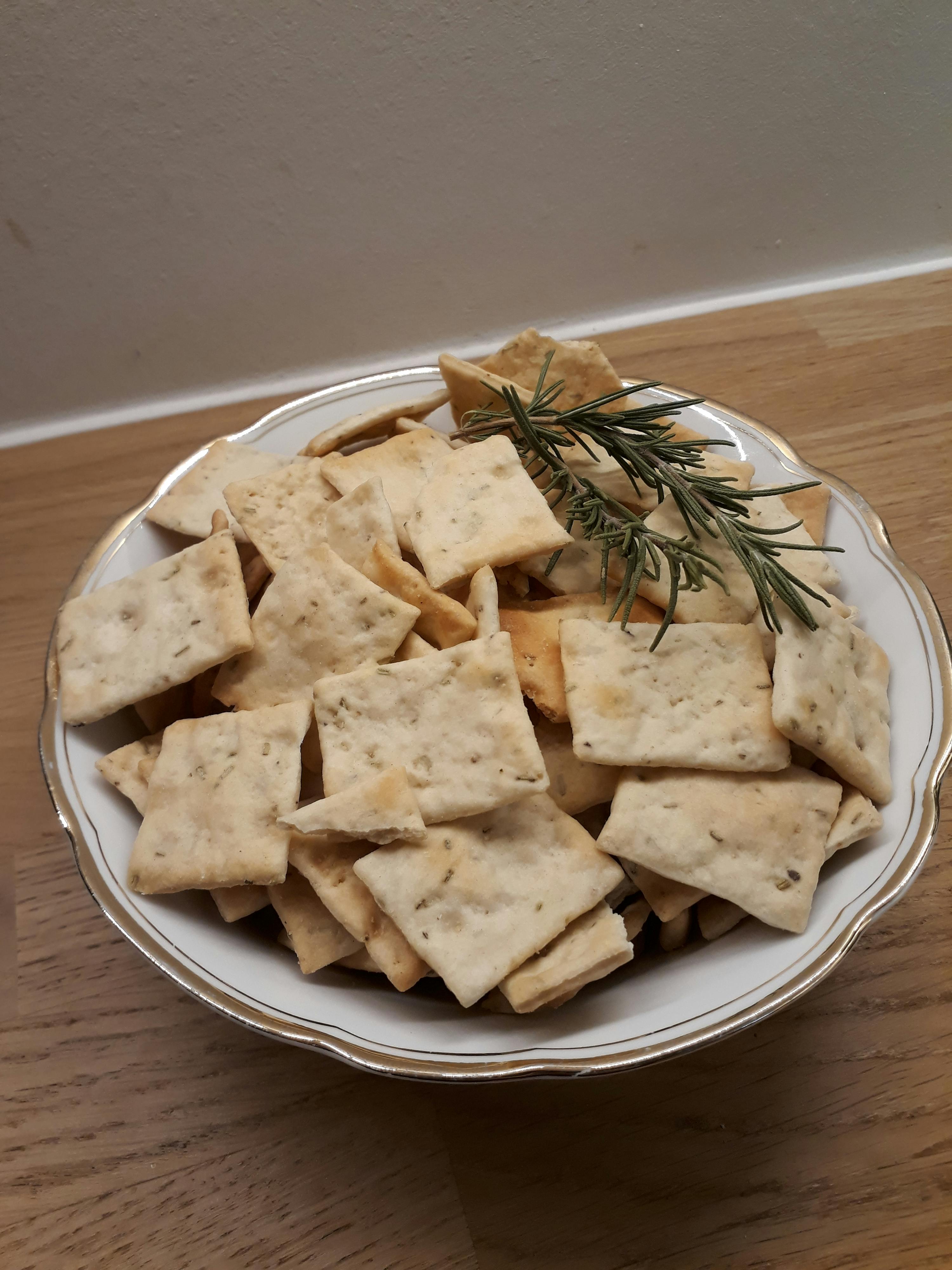 un piatto di crackers con un rametto di rosmarino sopra