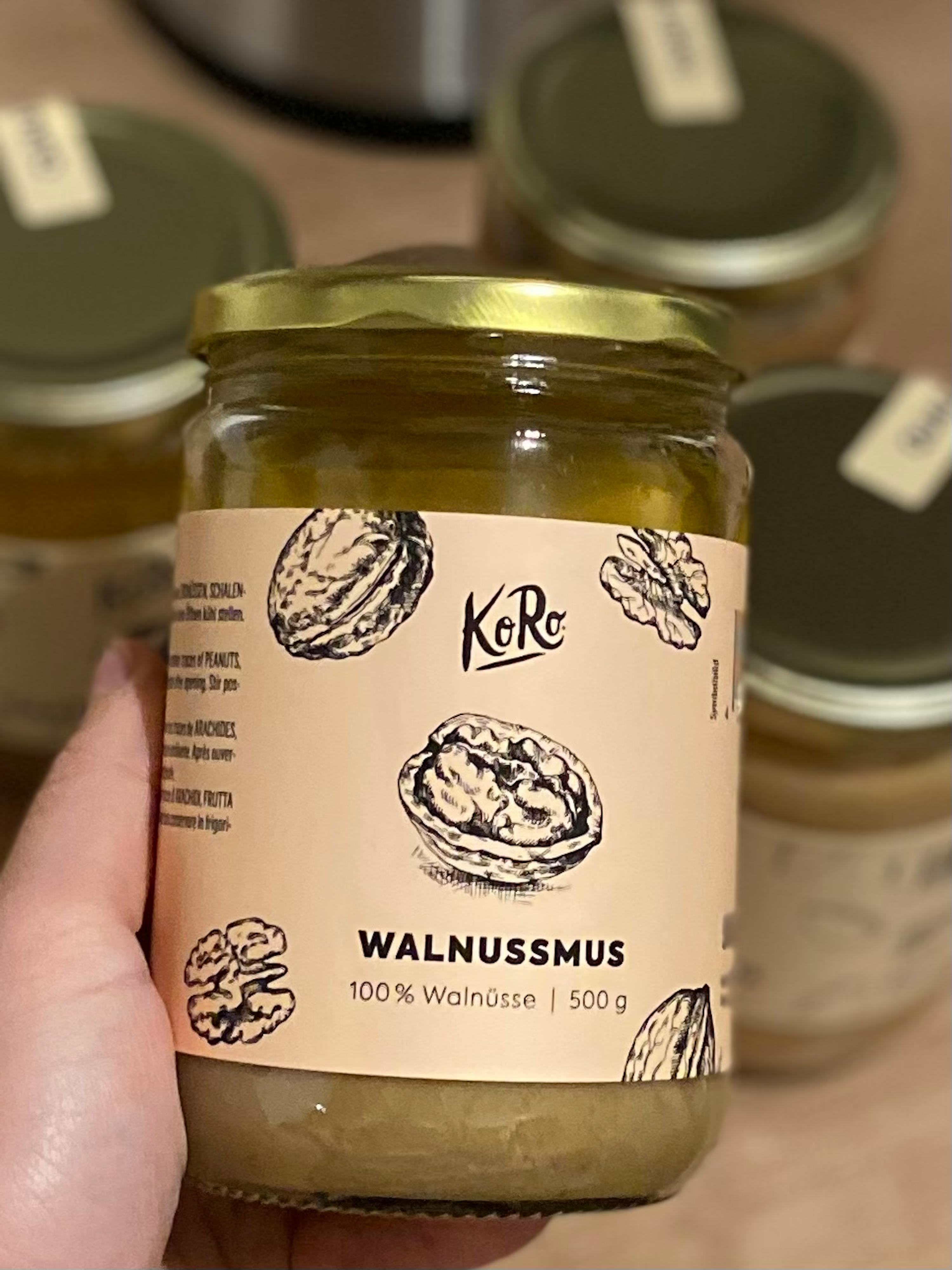 a person is holding a jar of walnussmus