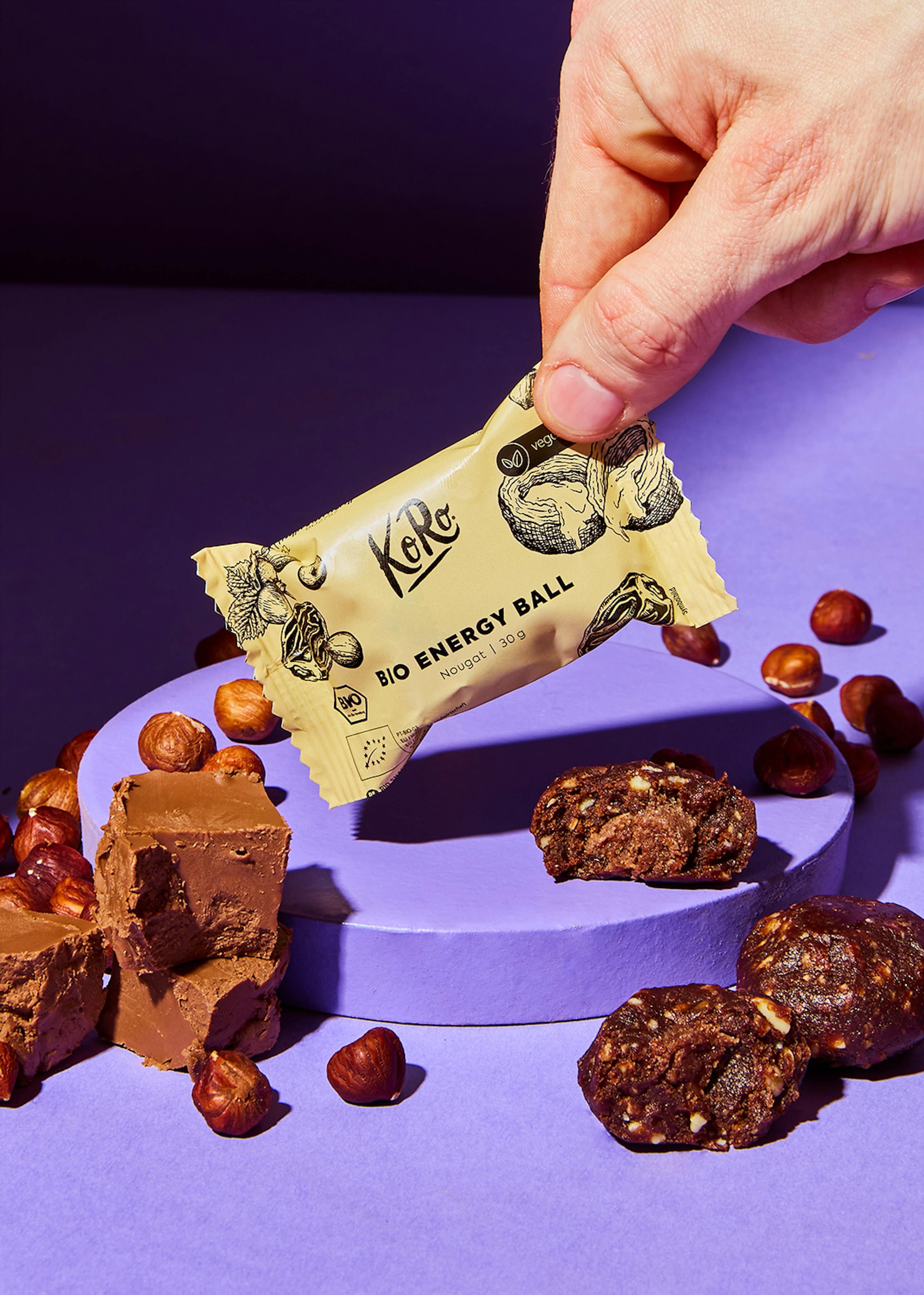 a person is holding a bio energy ball on a purple surface