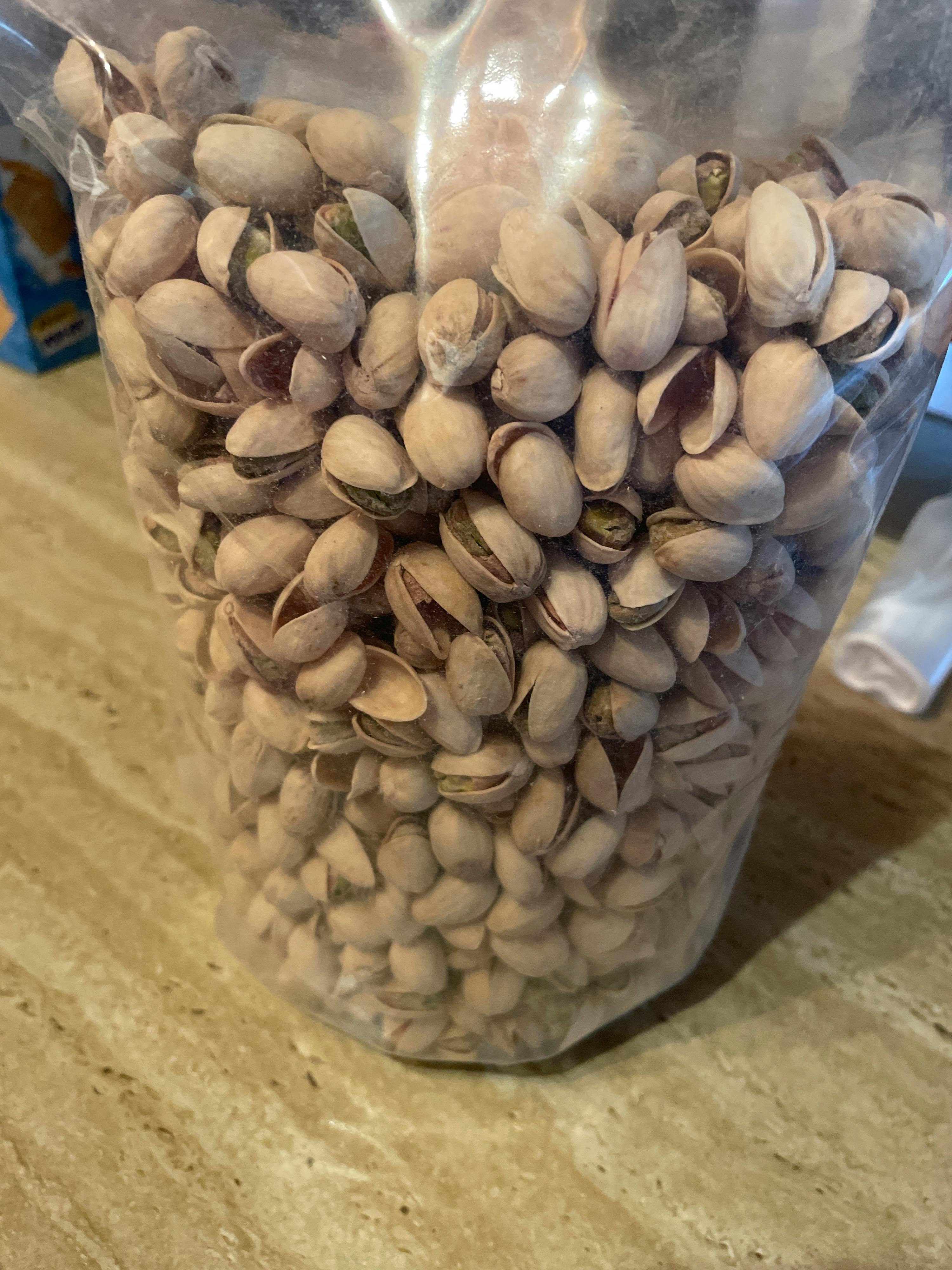 eine Tüte Pistazien steht auf einem Tisch