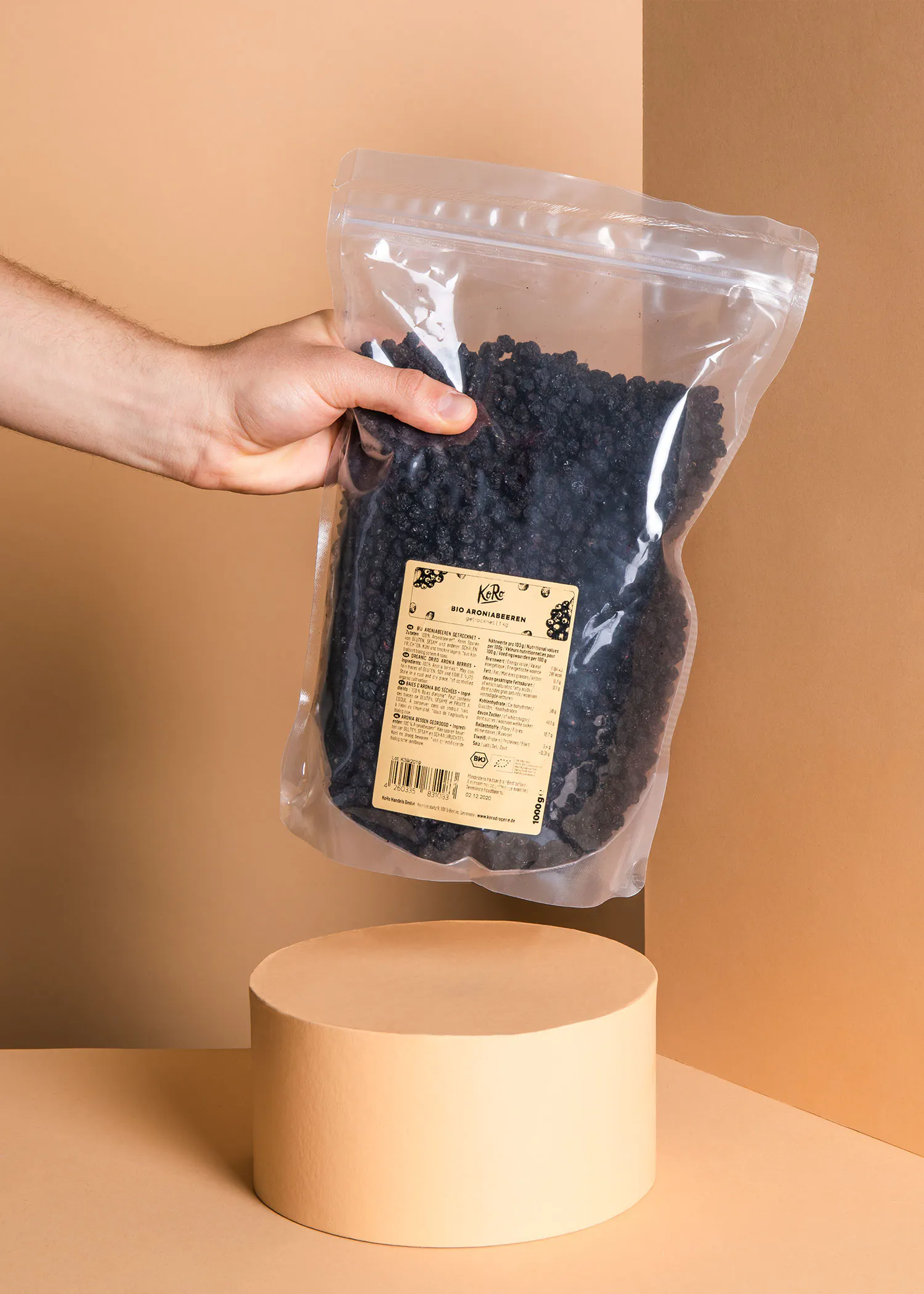 une personne tient un sac de raisins noirs avec une étiquette en bois