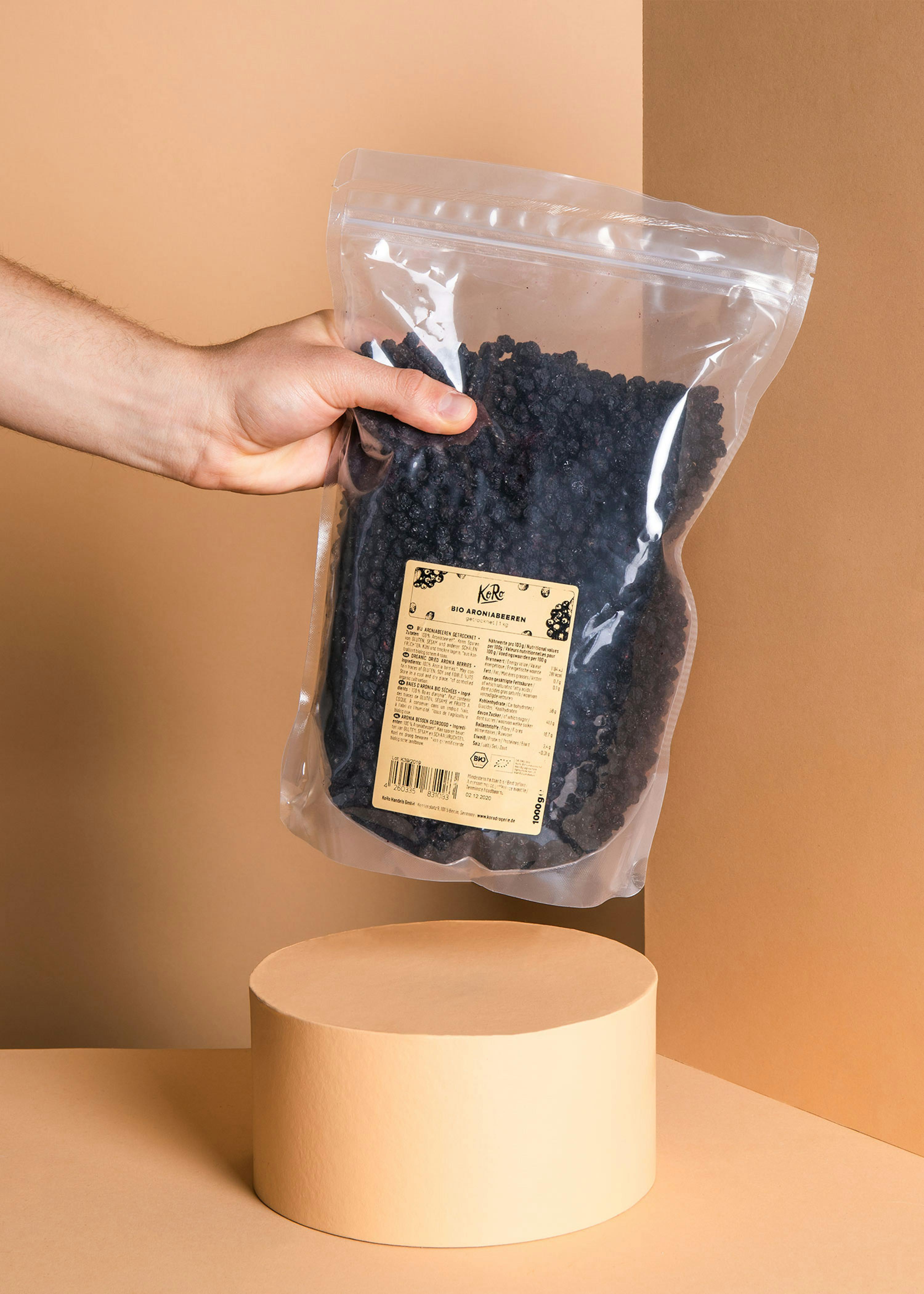 eine Person hält einen Plastikbeutel mit schwarzen Beeren darin