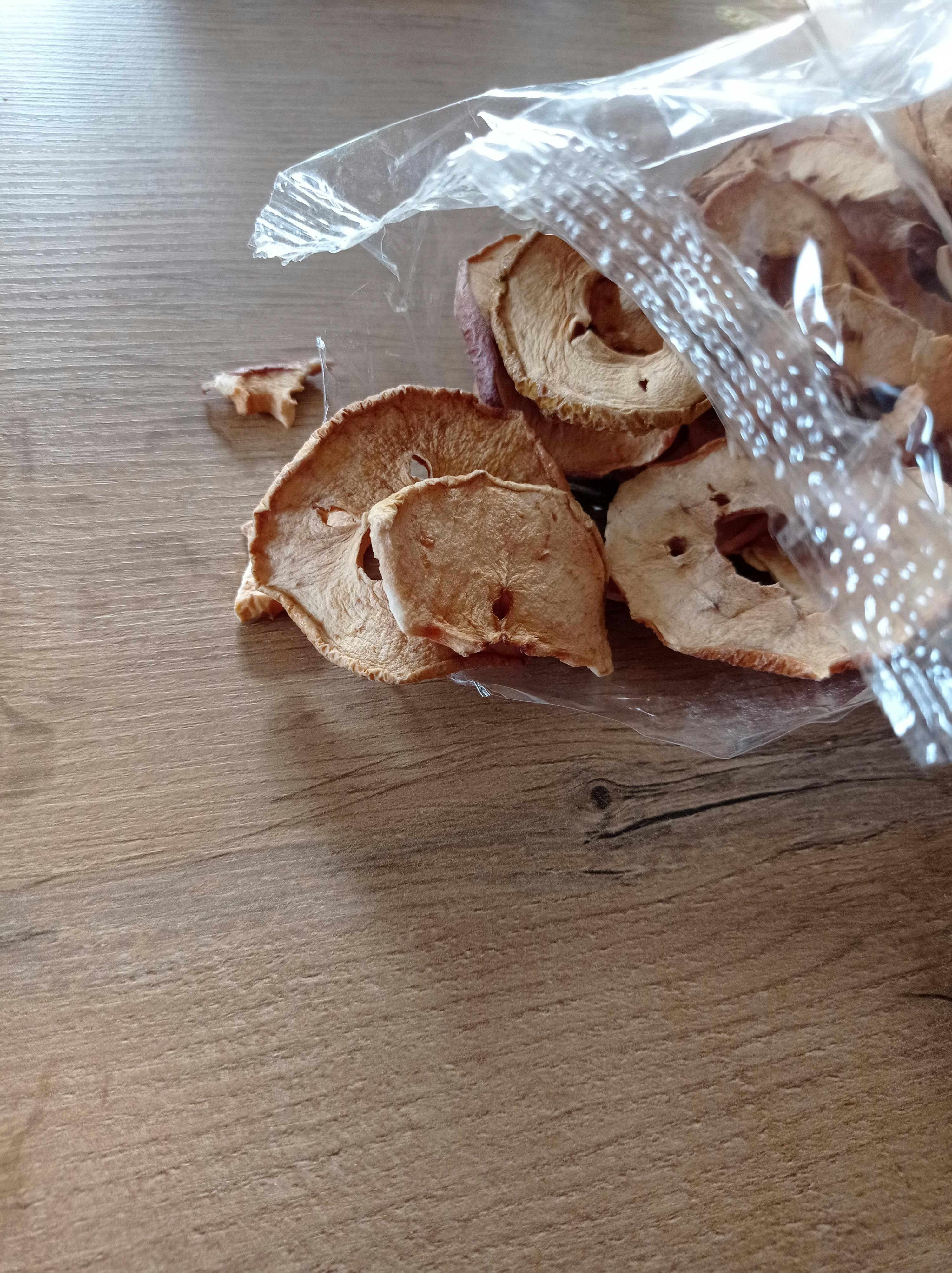 a bag of dried apples sits on a wooden table
