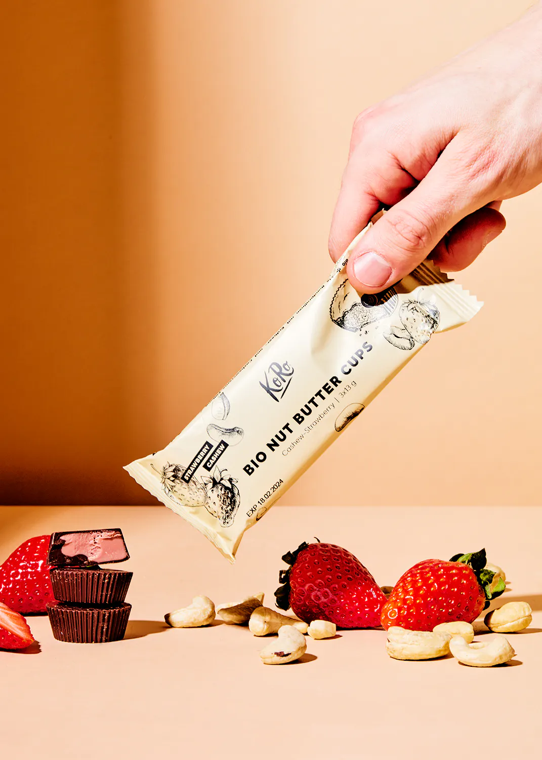 une personne tient un paquet de tasses de beurre de noix bio