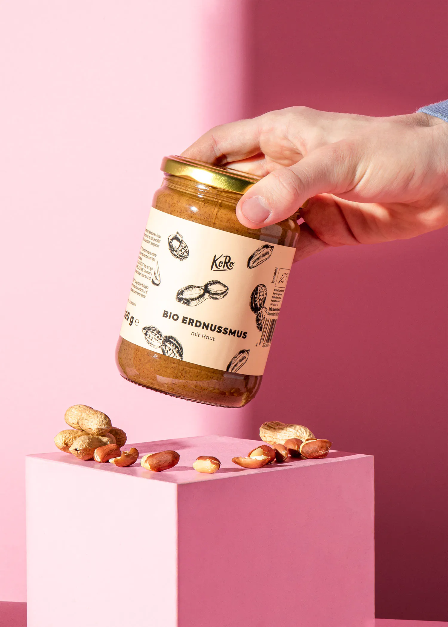 une personne tient un bocal de beurre d' arachide bio