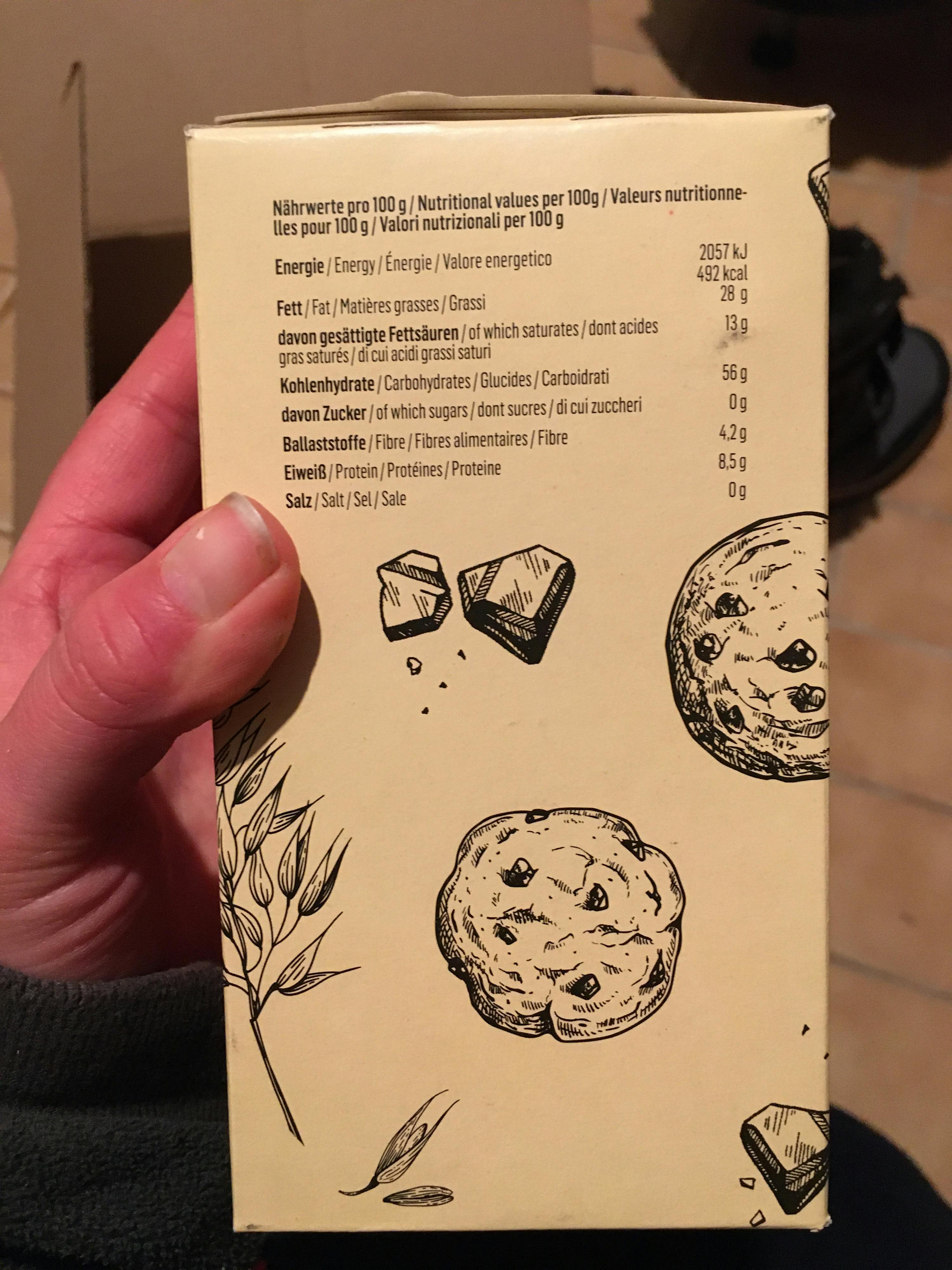 une personne tient une boîte de biscuits aux pépites de chocolat dans sa main