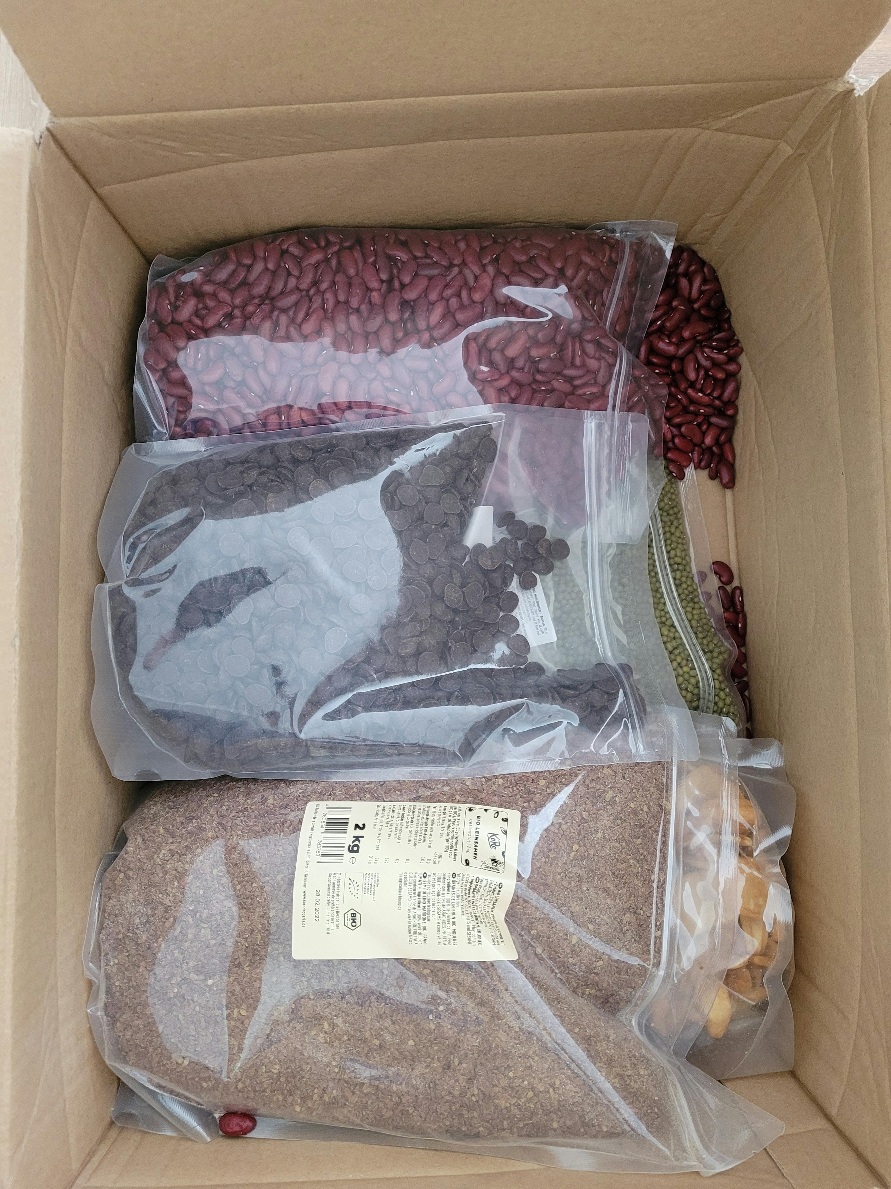three bags of food in a cardboard box one of which says 2 kg