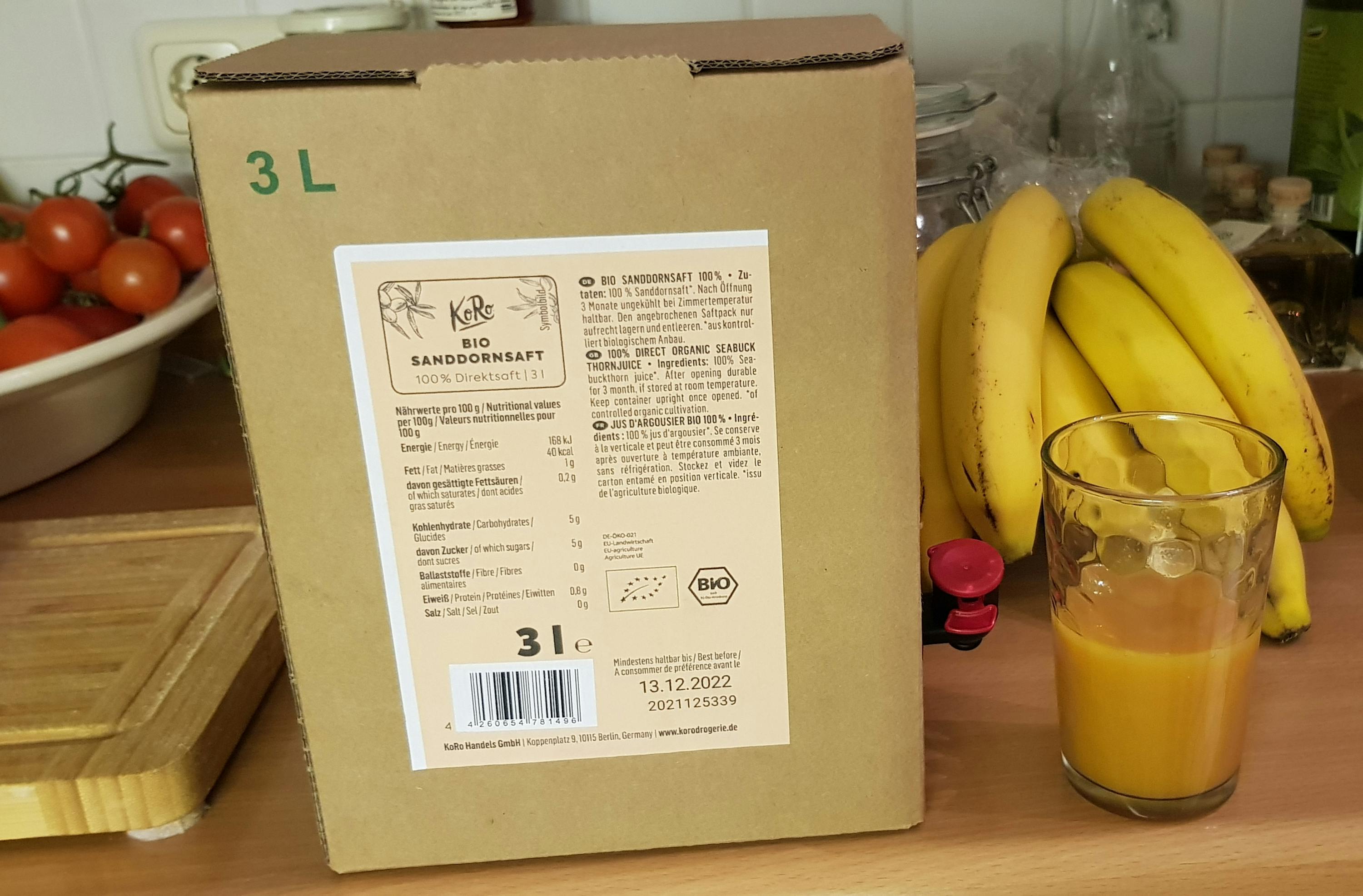 un bicchiere di succo di banana è accanto a una scatola di cartone