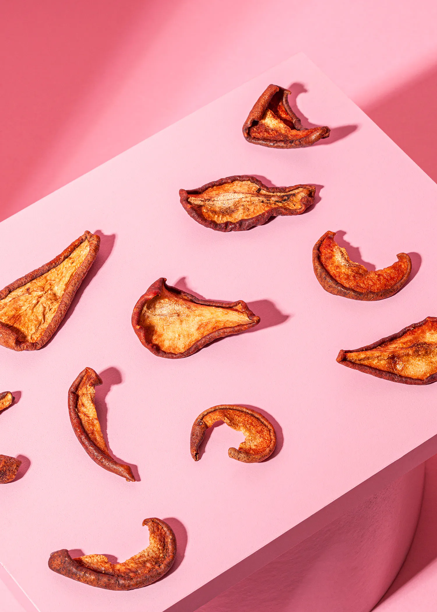 un tas de pommes séchées sur une table rose