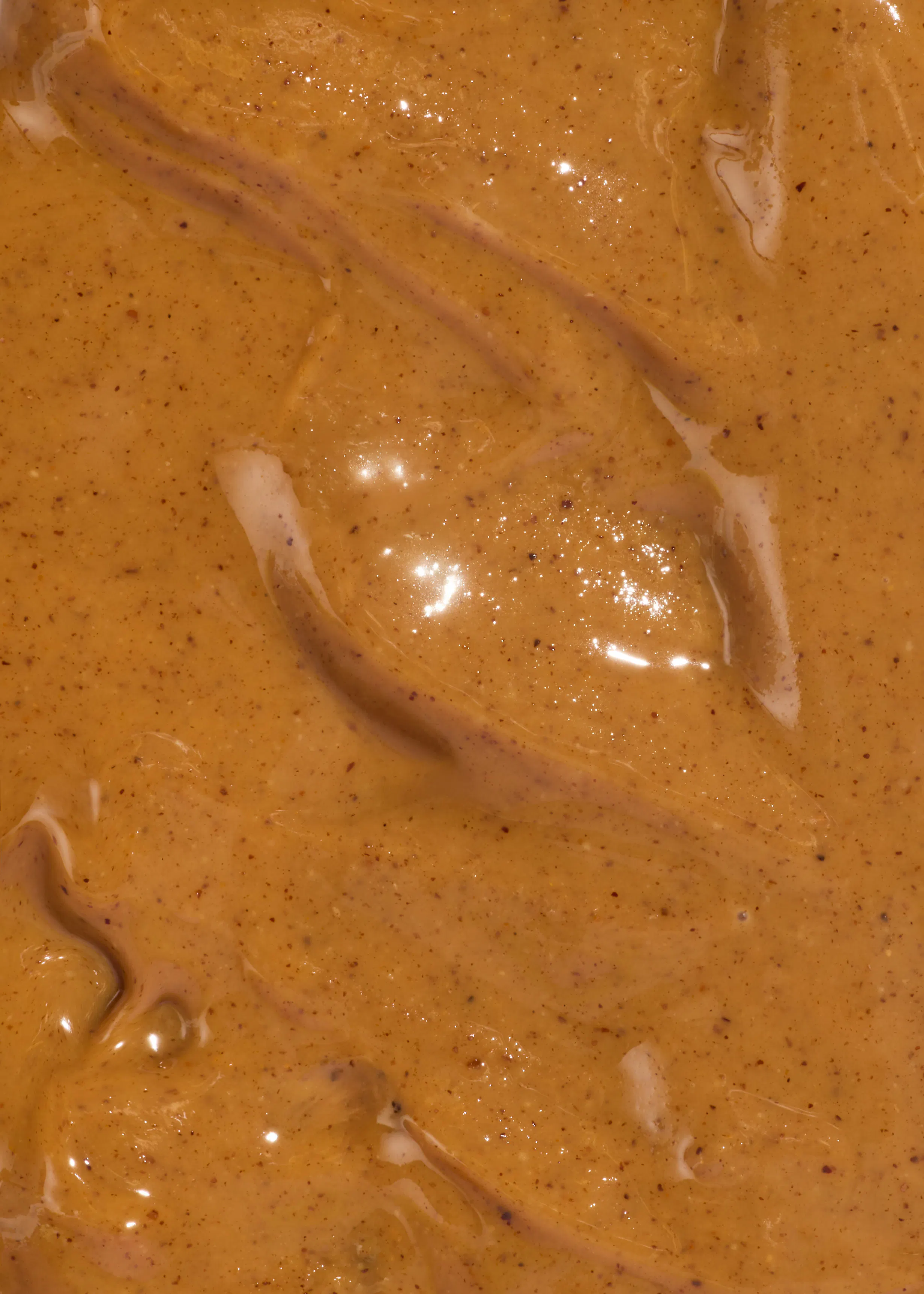 un gros plan d' une sauce brune avec des graines