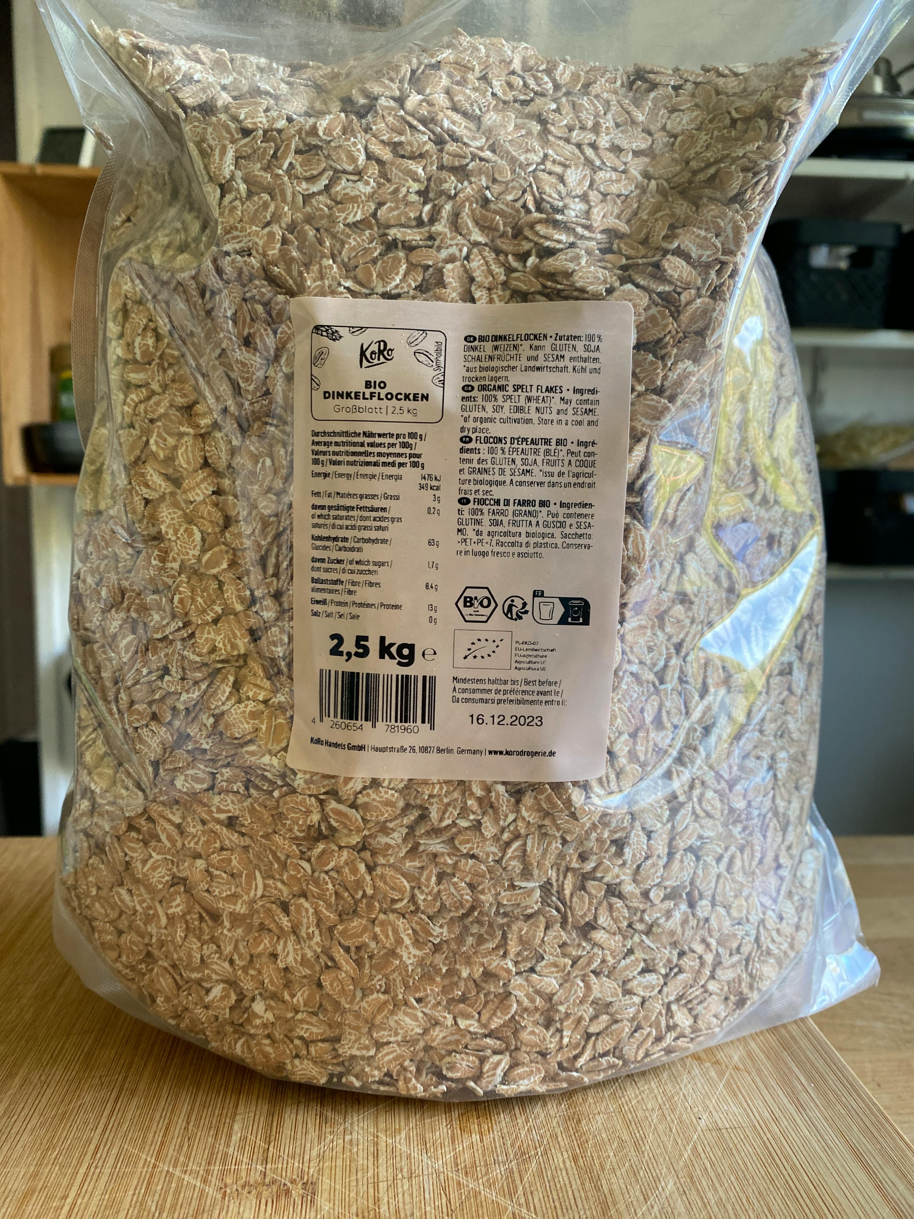 eine Tüte Haferflocken liegt auf einem Holztisch