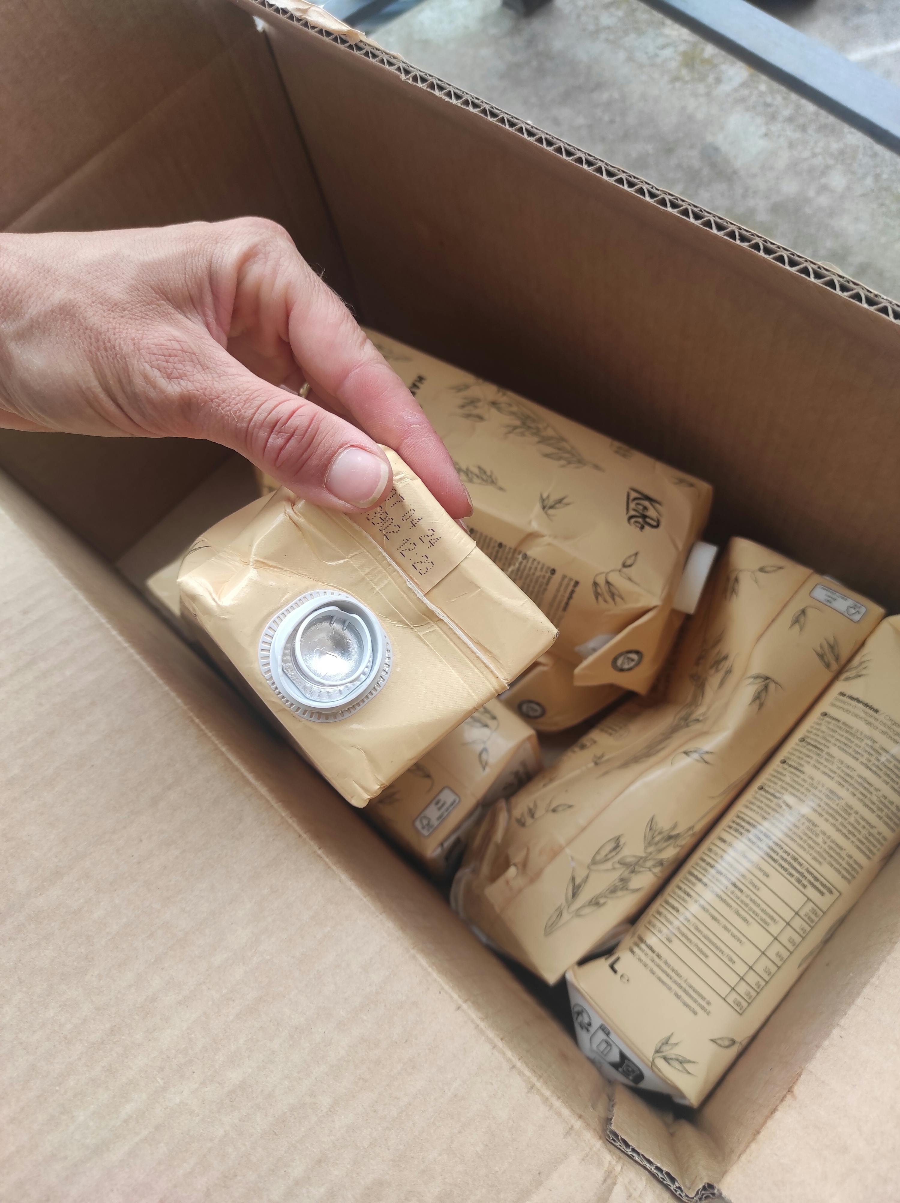 a person is holding a carton of k & b milk