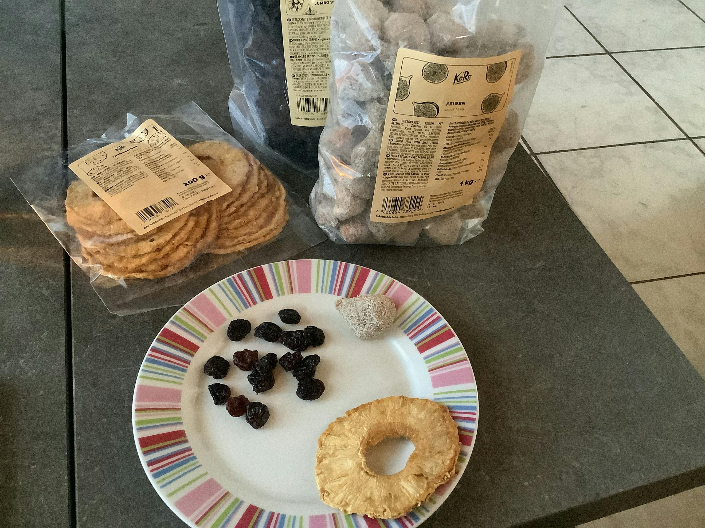 deux sacs de fruits séchés sont posés à côté d' une assiette de fruits séchés