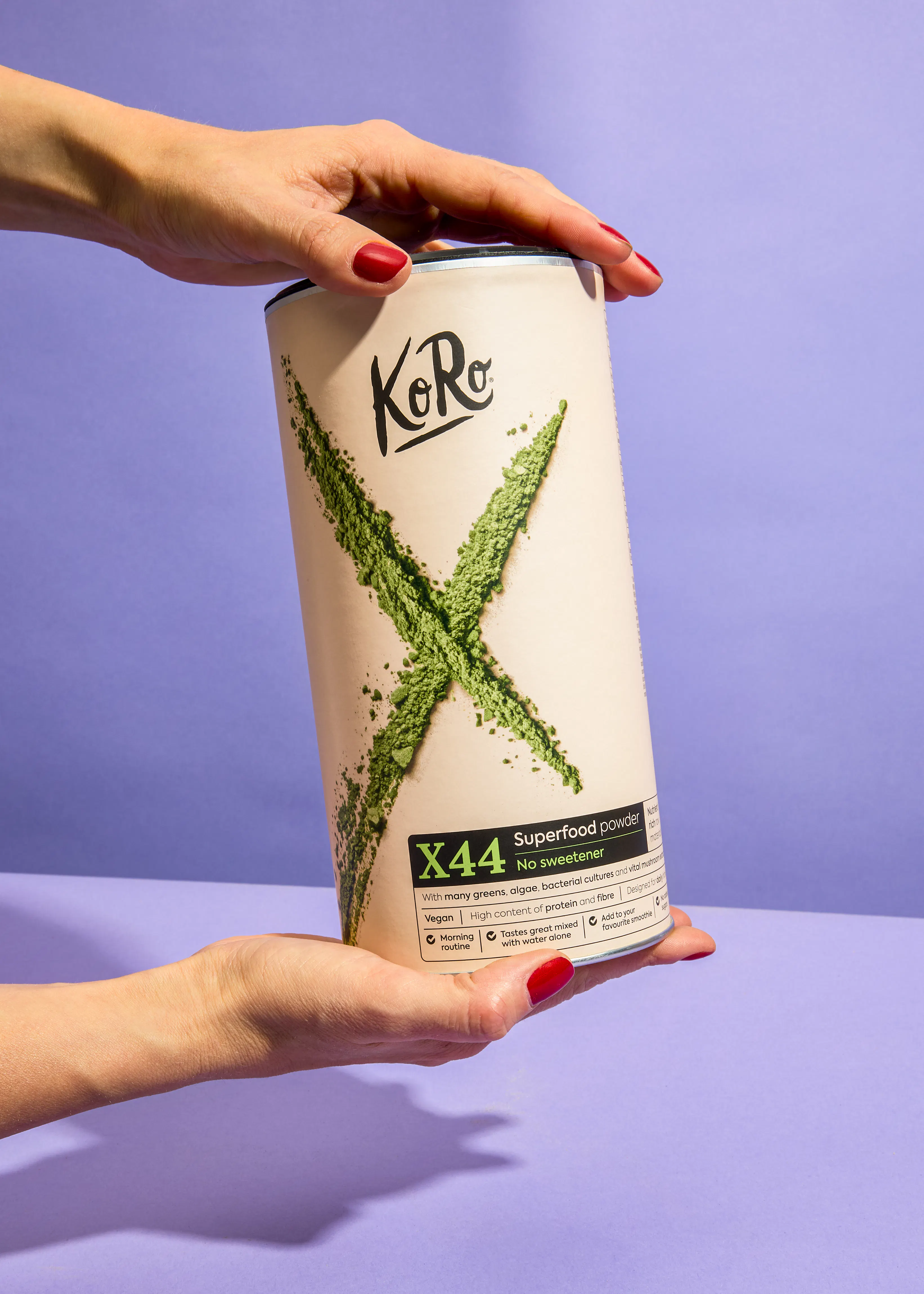 Eine Frau hält eine Dose Superfood-Pulver in ihren Händen