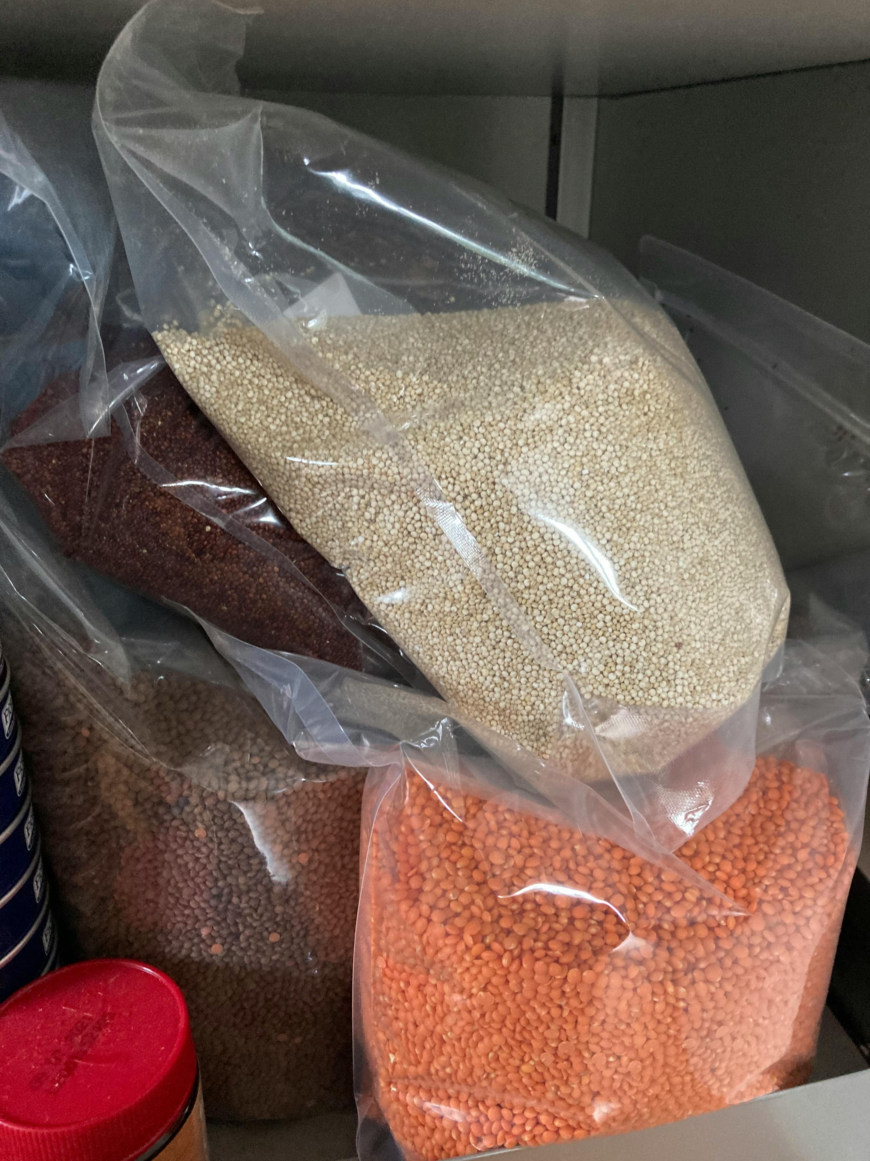 a bag of quinoa sits next to a bag of lentils