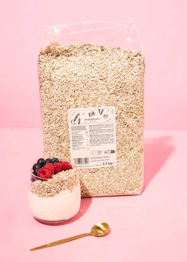 un sac de flocons d' avoine est assis à côté d' un bol de yaourt