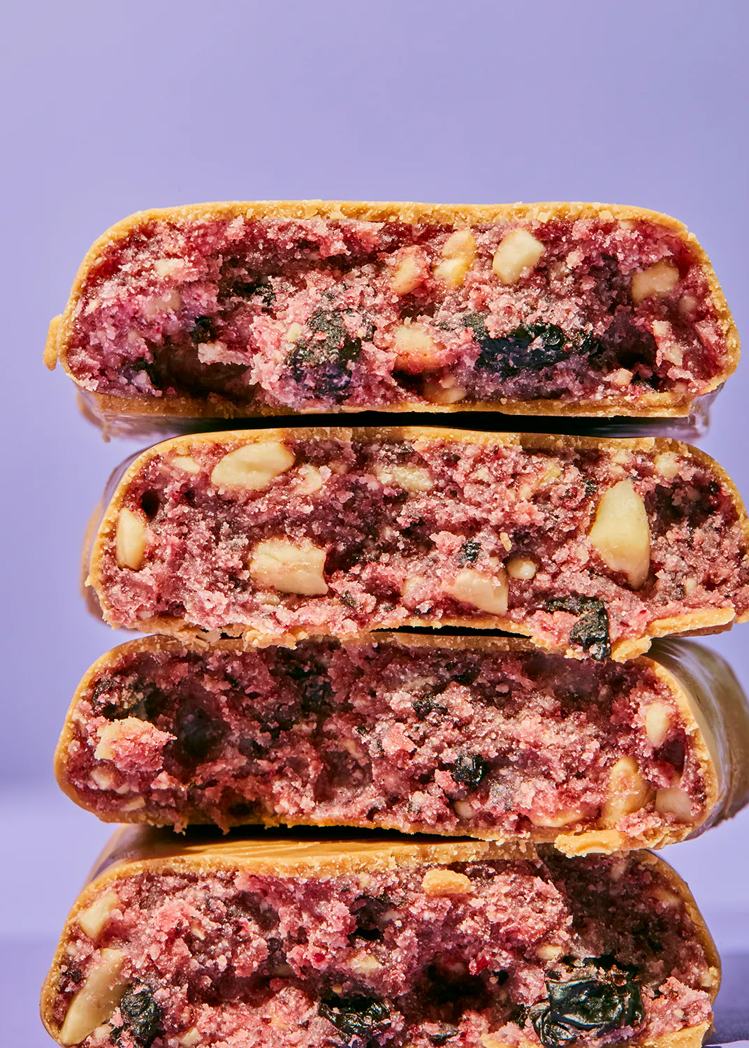 quatre biscuits empilés les uns sur les autres avec des baies et des noix