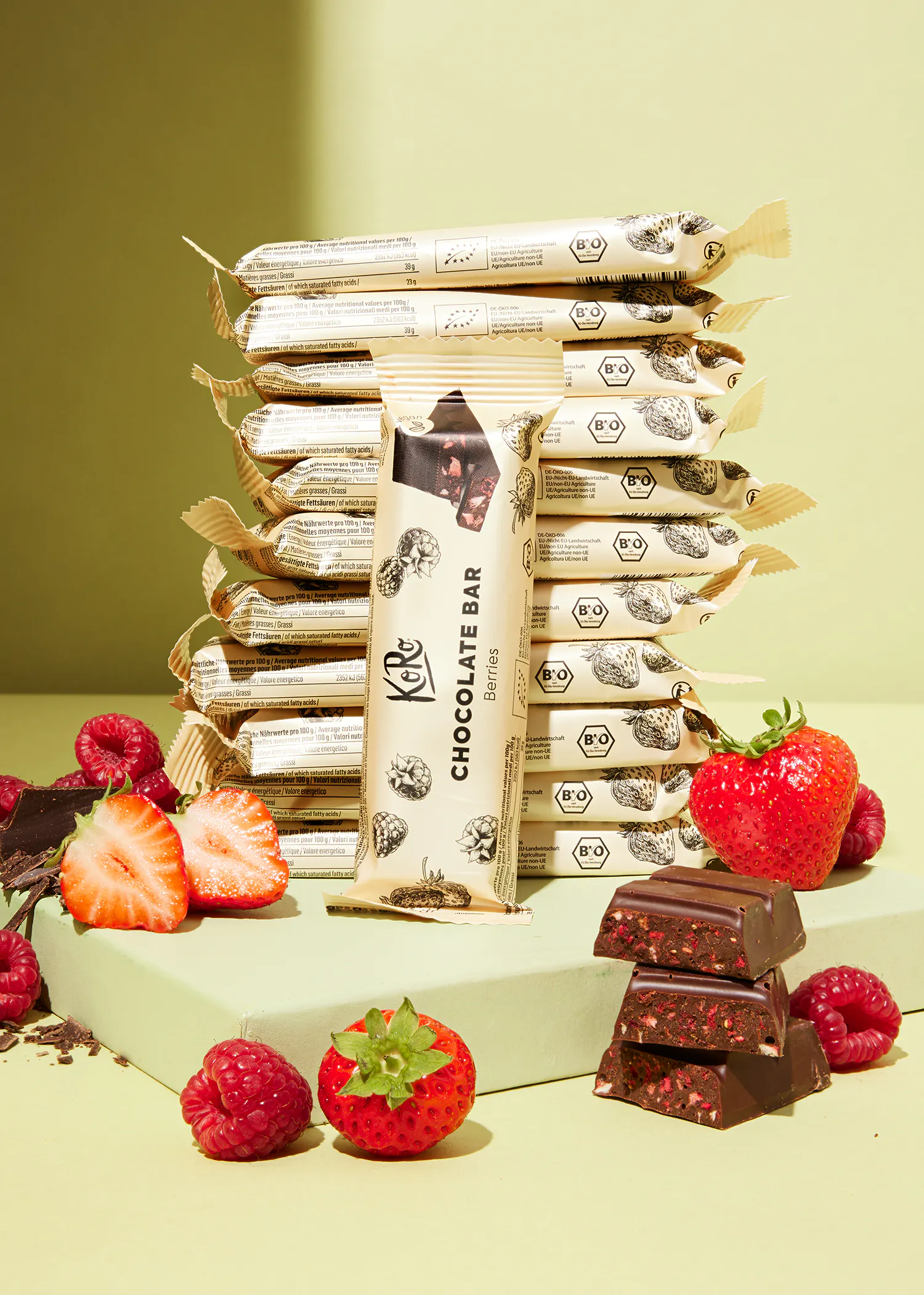 a stack of chocolate bars with strawberries and raspberries