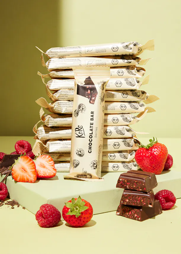 a stack of chocolate bars with strawberries and raspberries