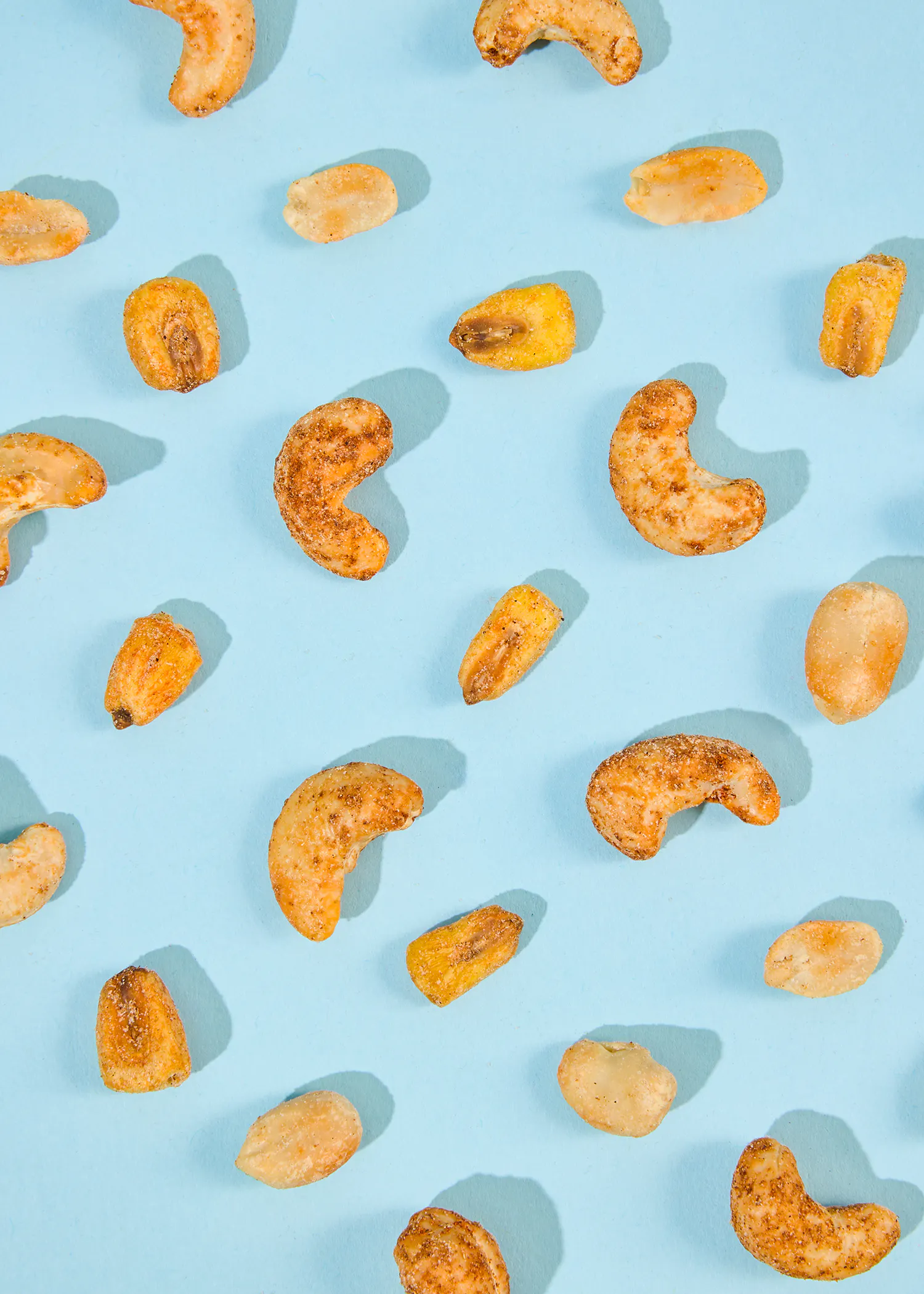 a pattern of cashews and peanuts on a blue surface