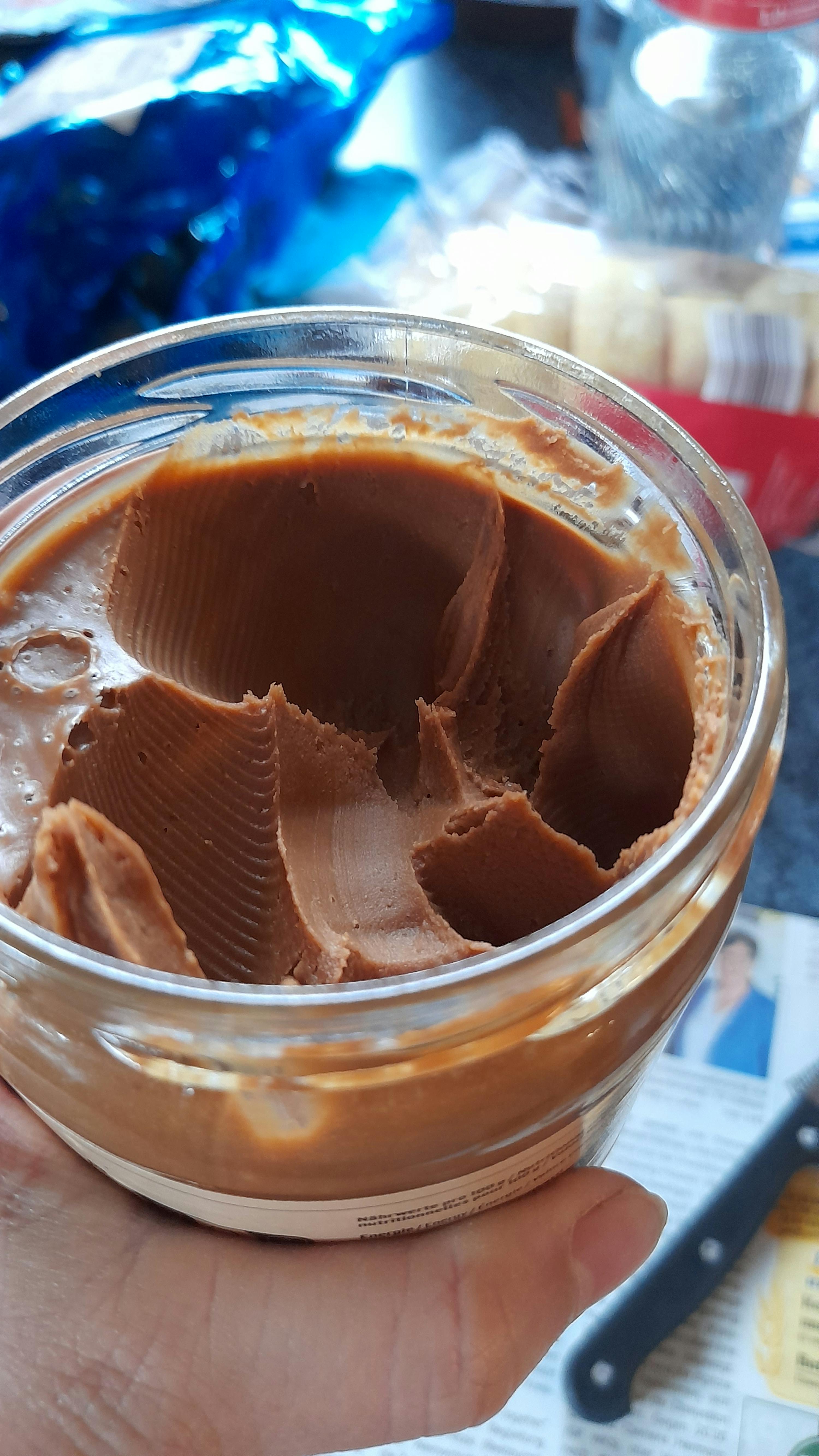 a person is holding a jar of peanut butter that has been opened