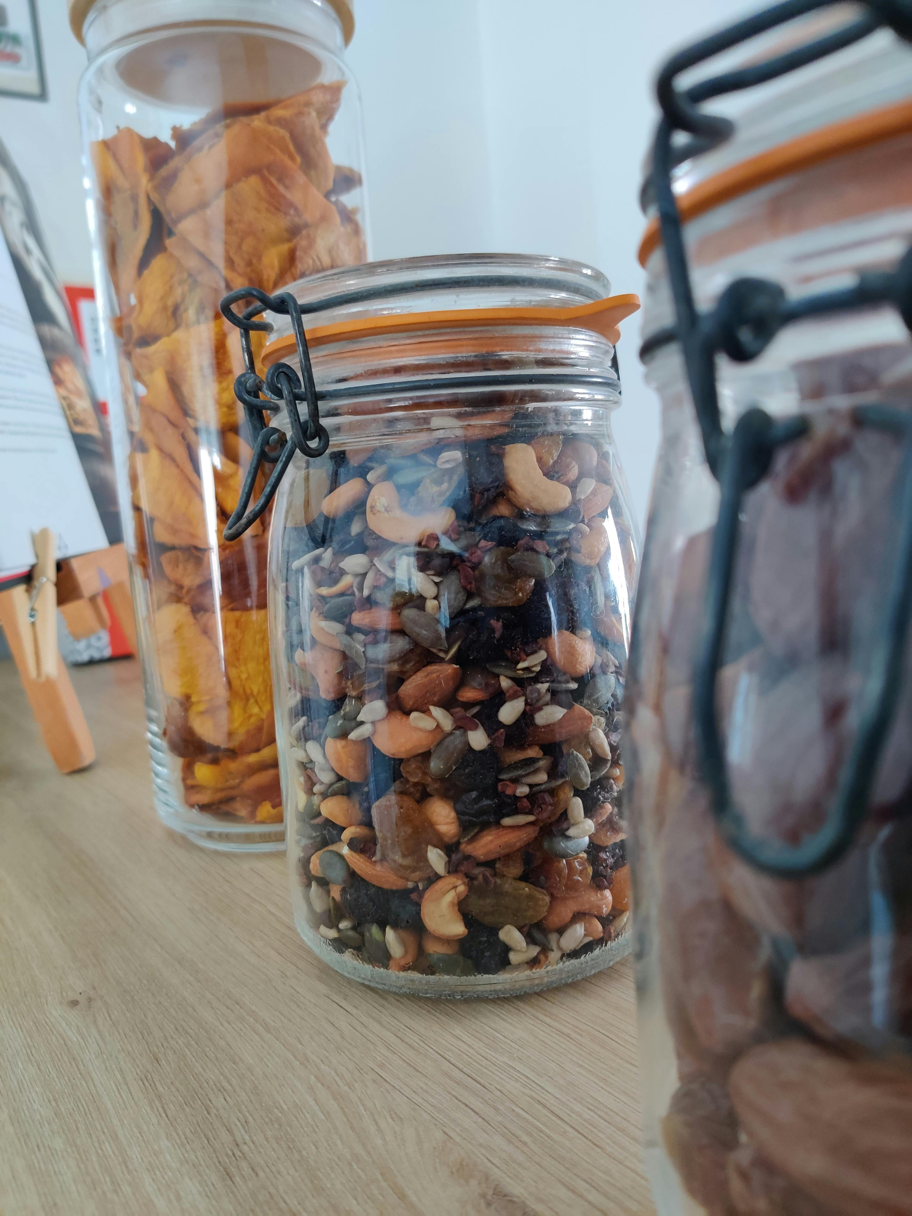 un bocal en verre rempli de noix et de fruits secs