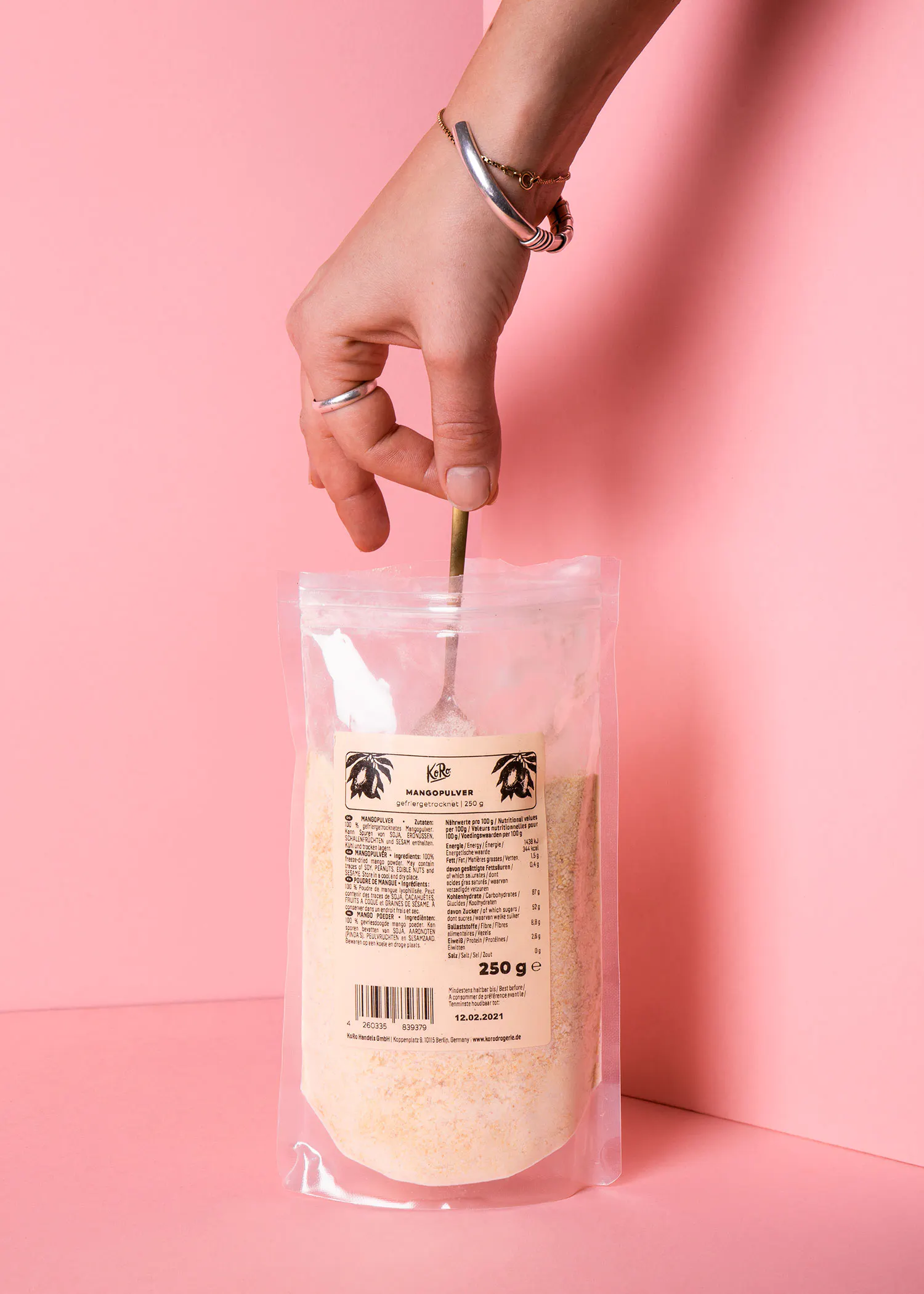 une personne tient une cuillère à l' intérieur d' un sac en plastique de 250 g