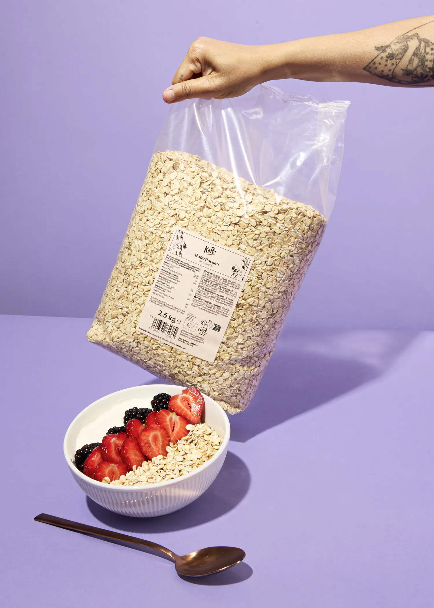 une personne tient un sac de flocons d' avoine à côté d' un bol de flocons d' avoine