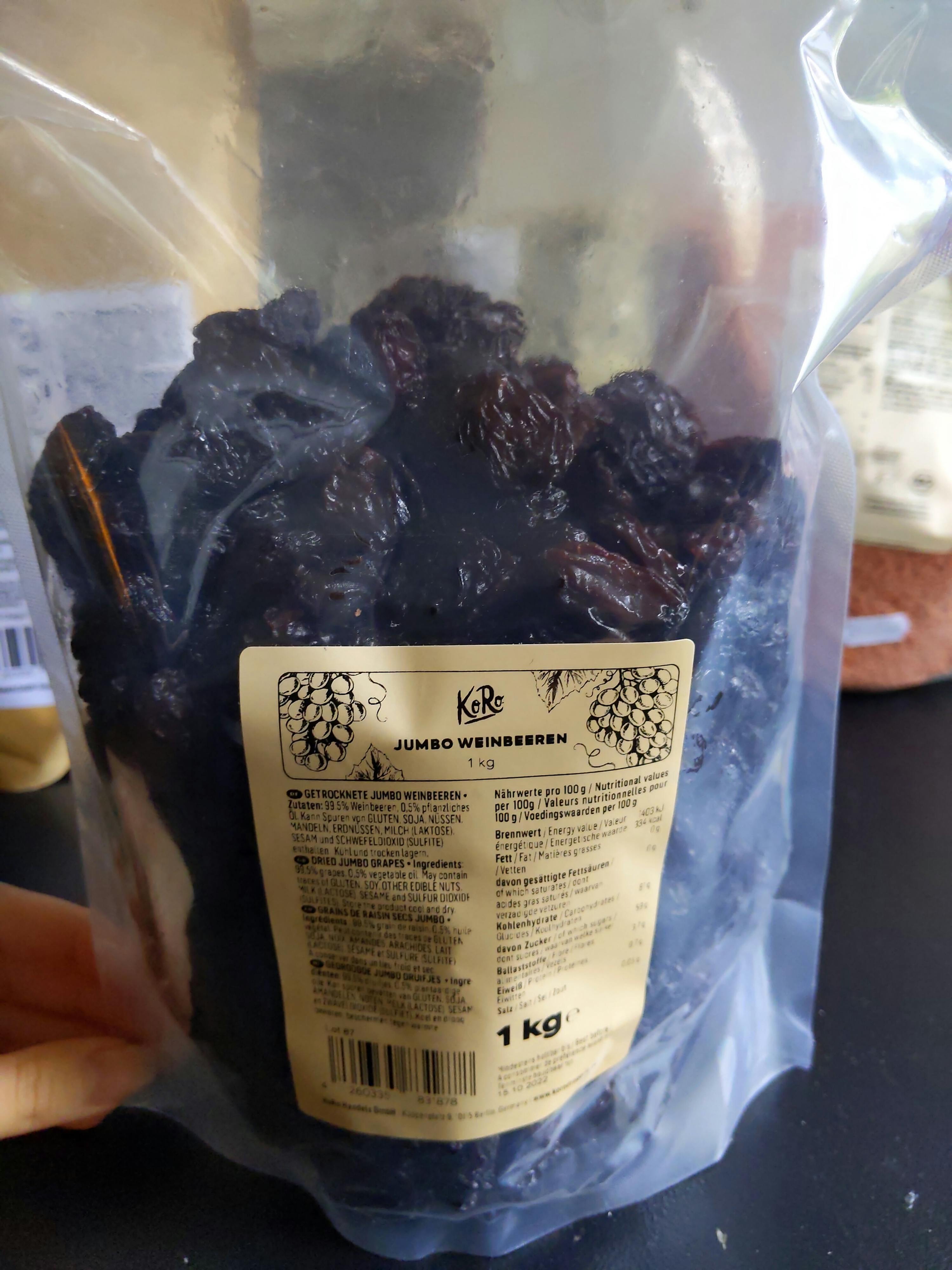 eine Person hält einen Plastikbeutel mit jumbo-Weinenbeeren in der Hand