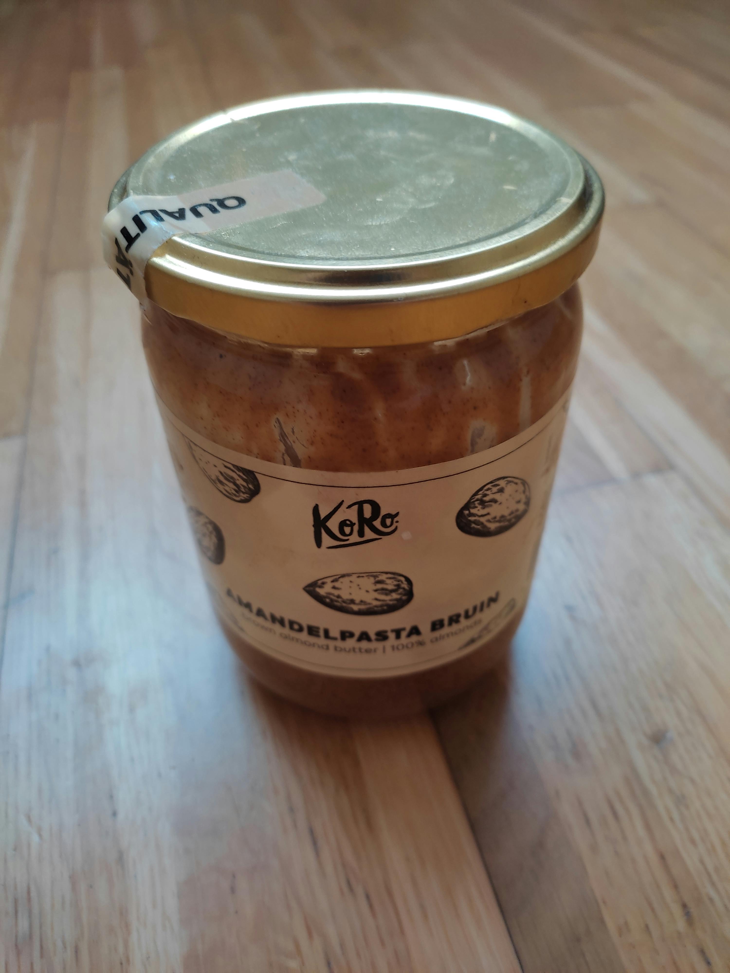 un bocal de mandelpasta brun avec un couvercle doré