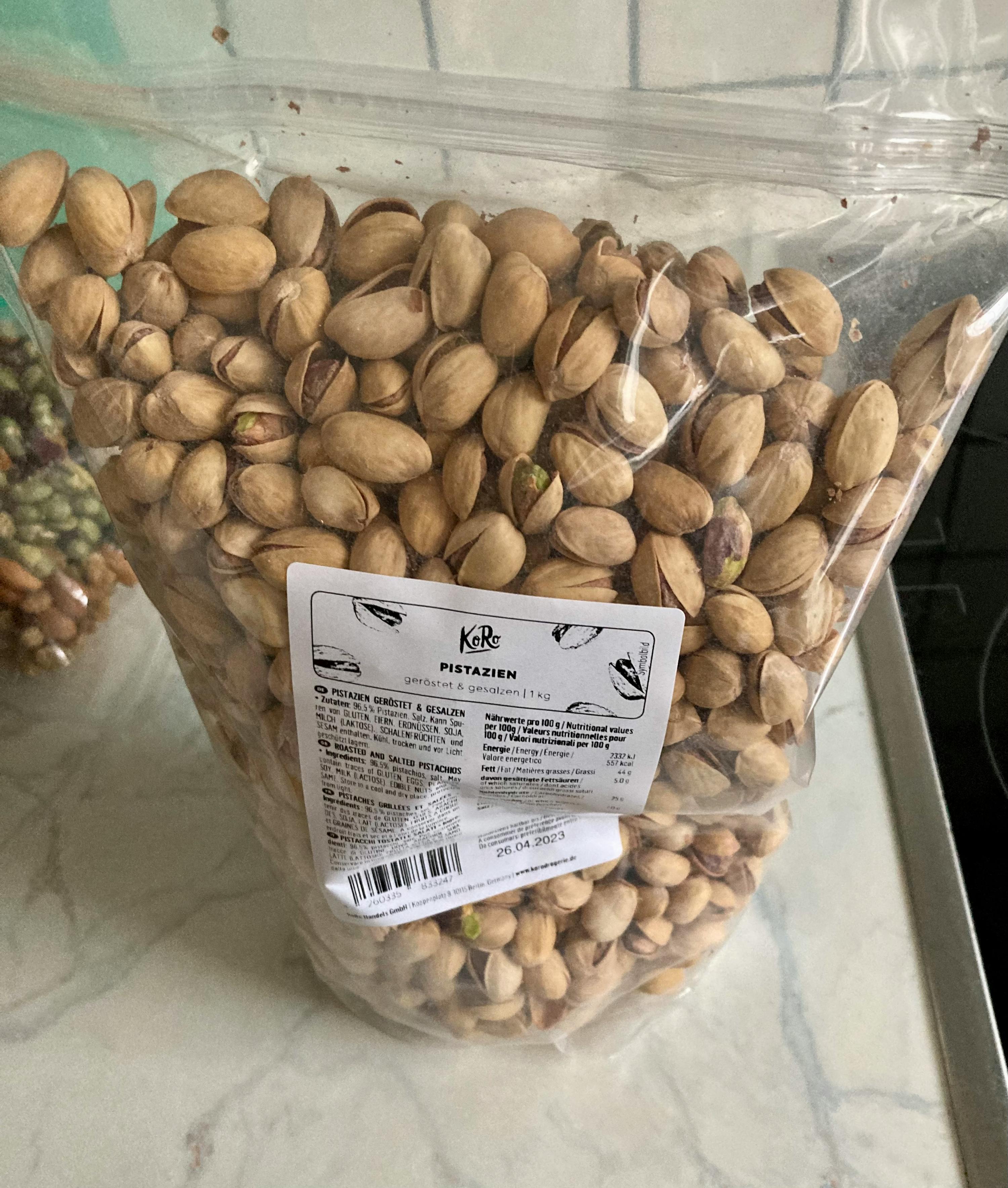 eine Plastiktüte mit pistazien steht auf einem Tisch