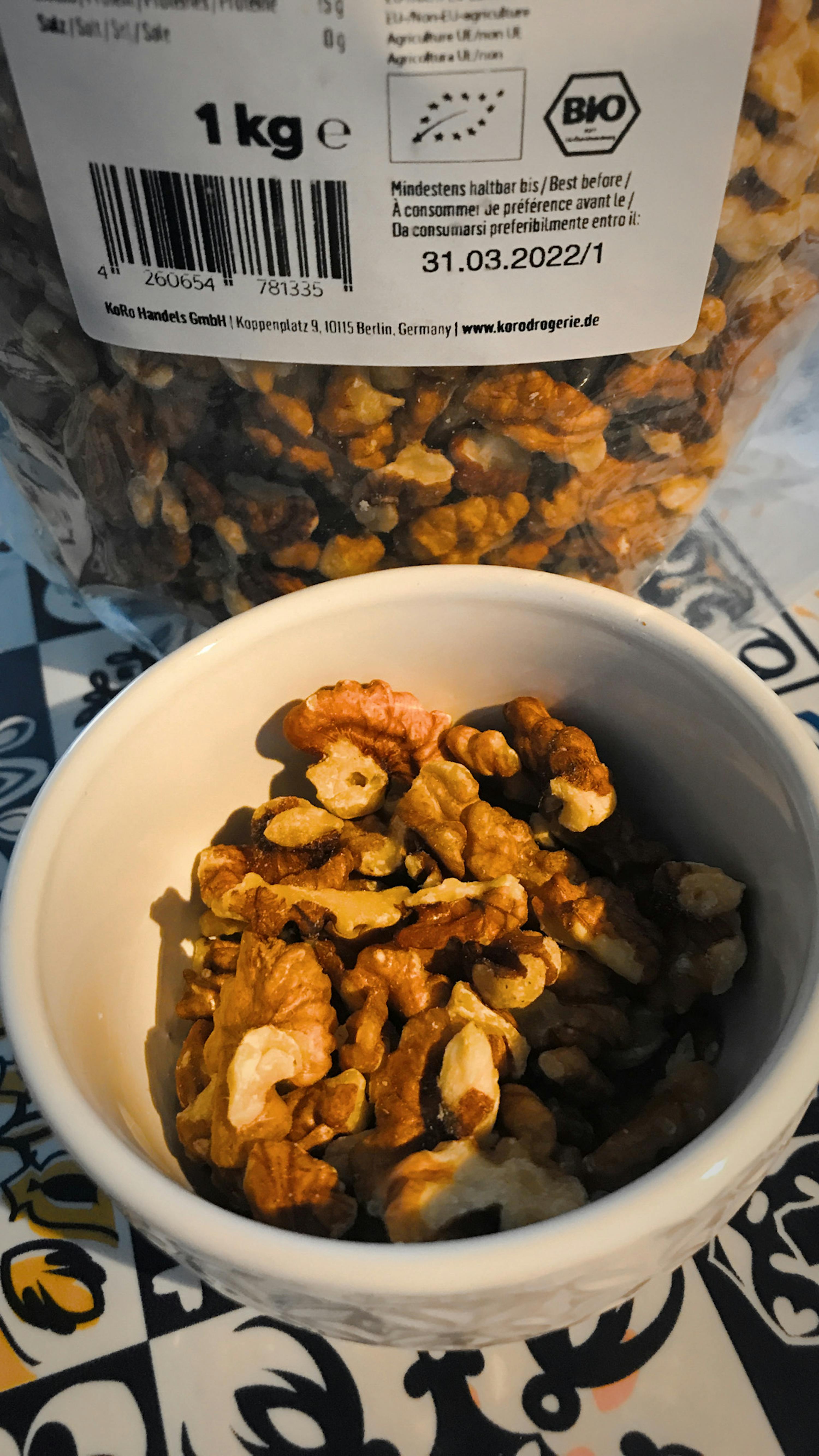 un bol de noix assis à côté d' un sac de noix bio