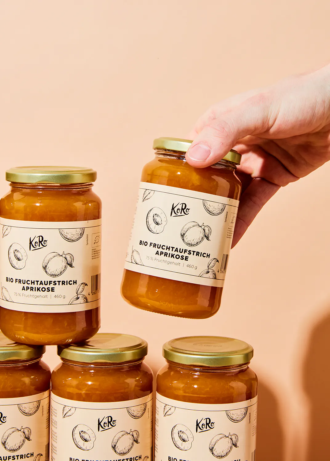 eine Person hält ein Glas Bio-Früchteaufstrich aprikose