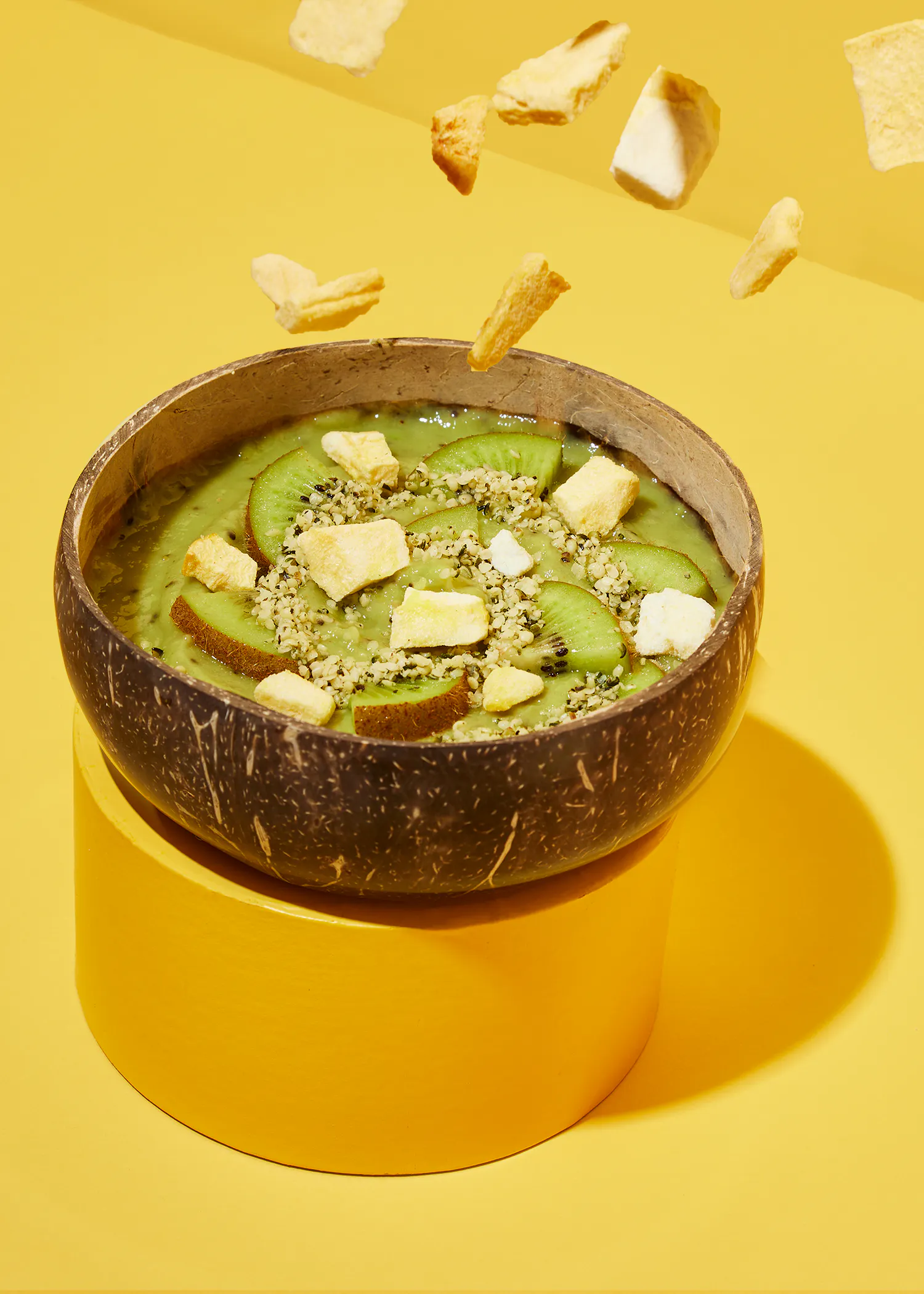 a bowl of green smoothie with kiwi slices and chips in it