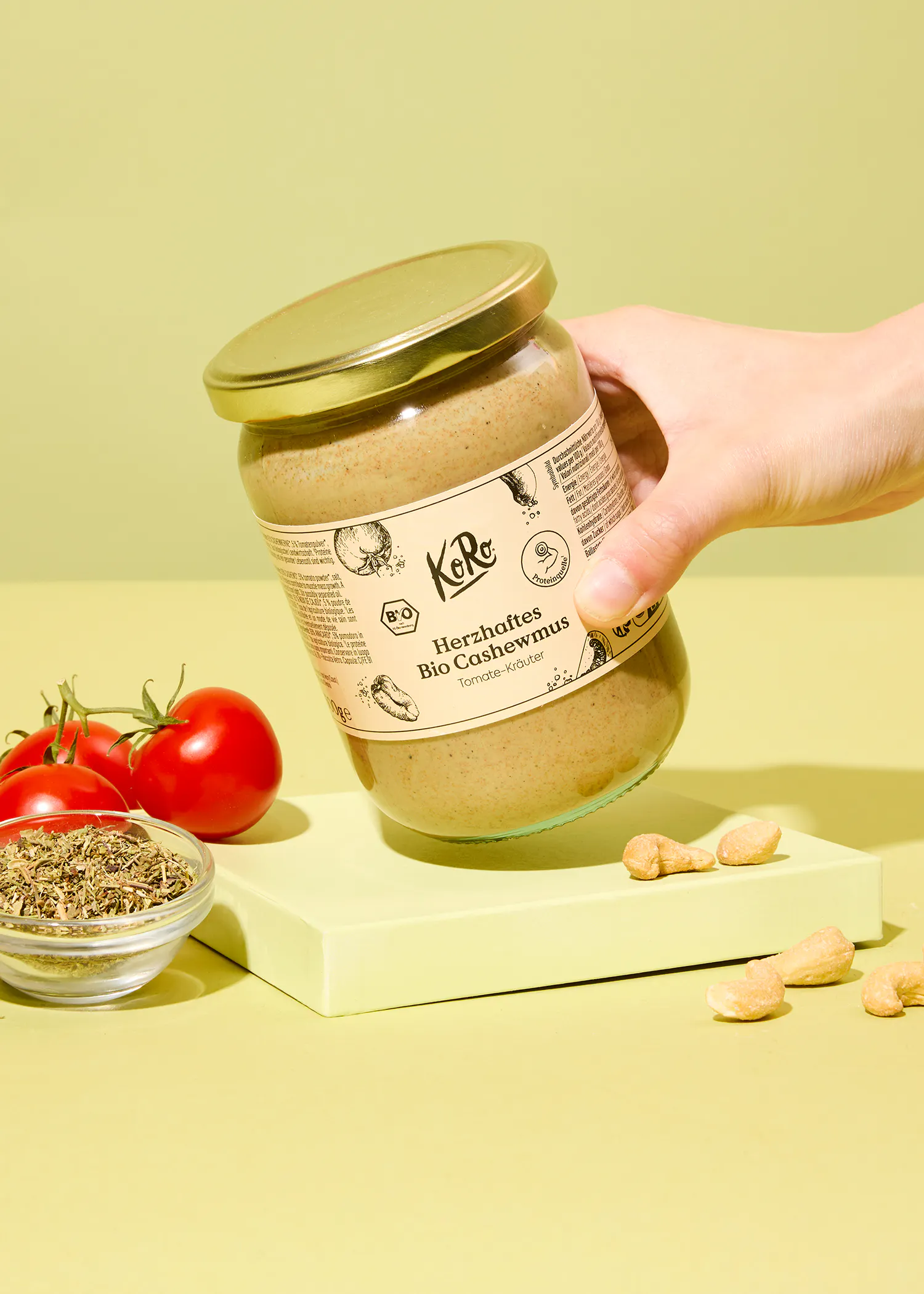 eine Person hält ein Glas herzhaftes Bio Cashewmus in der Hand