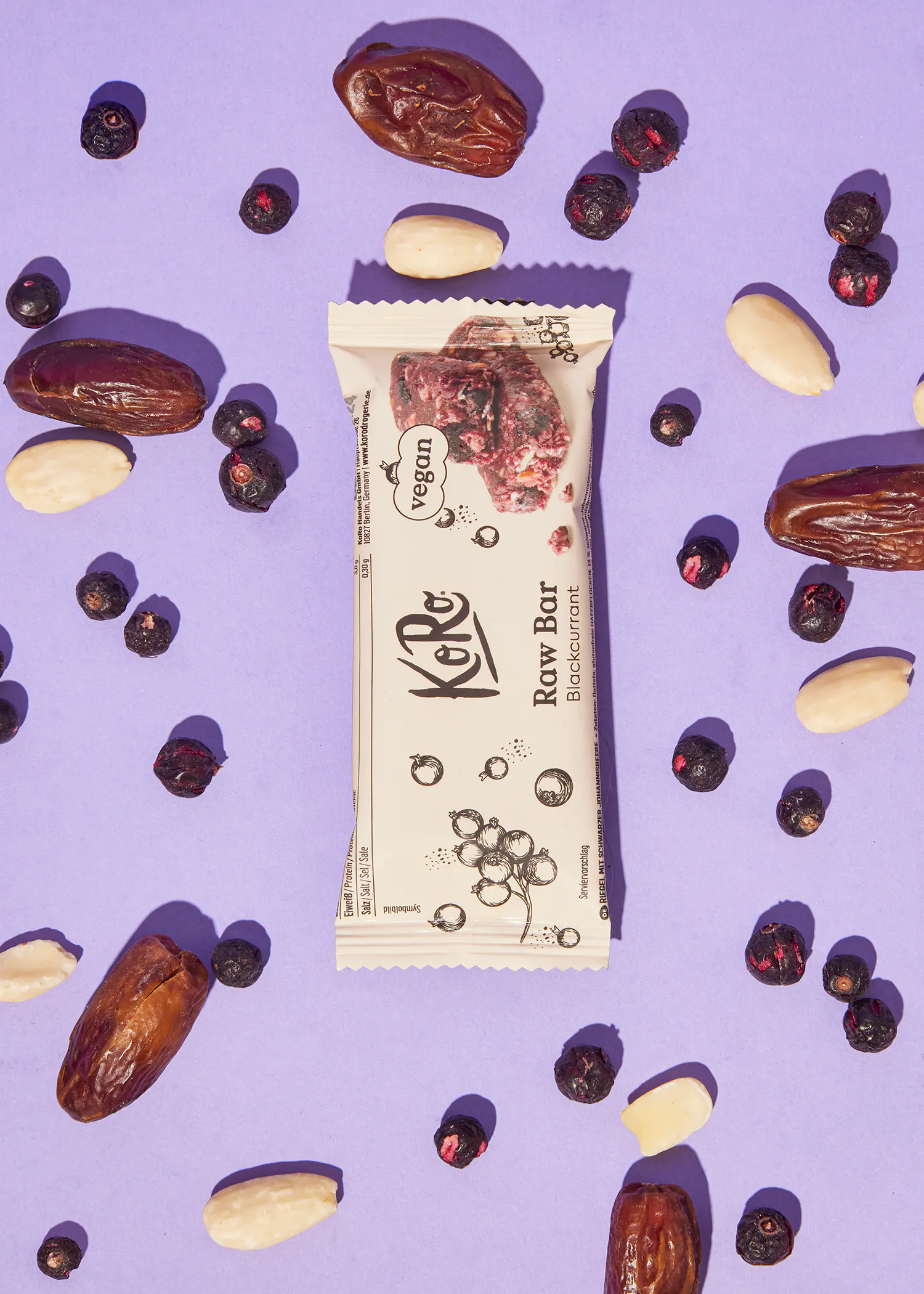 une barre végétalienne avec des dattes et des myrtilles sur fond violet