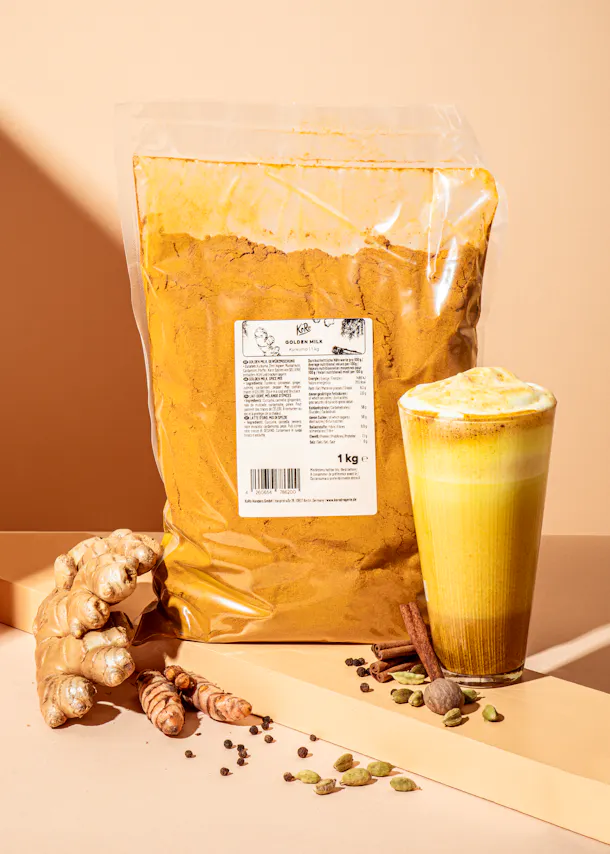 un sac de poudre de curcuma est posé à côté d' un verre de boisson