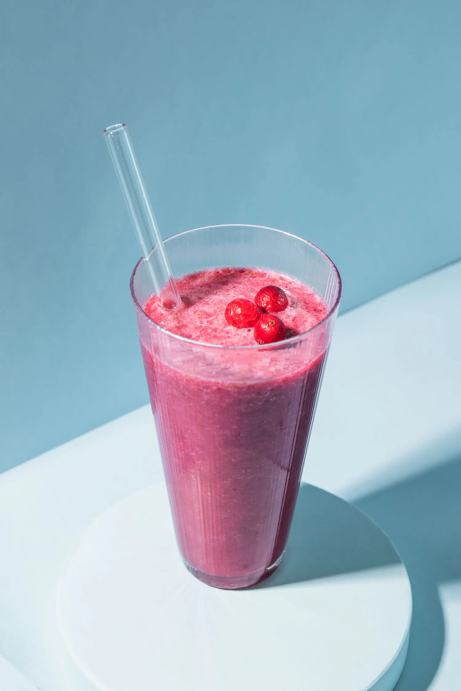 un batido de frambuesa con una pajita en un vaso