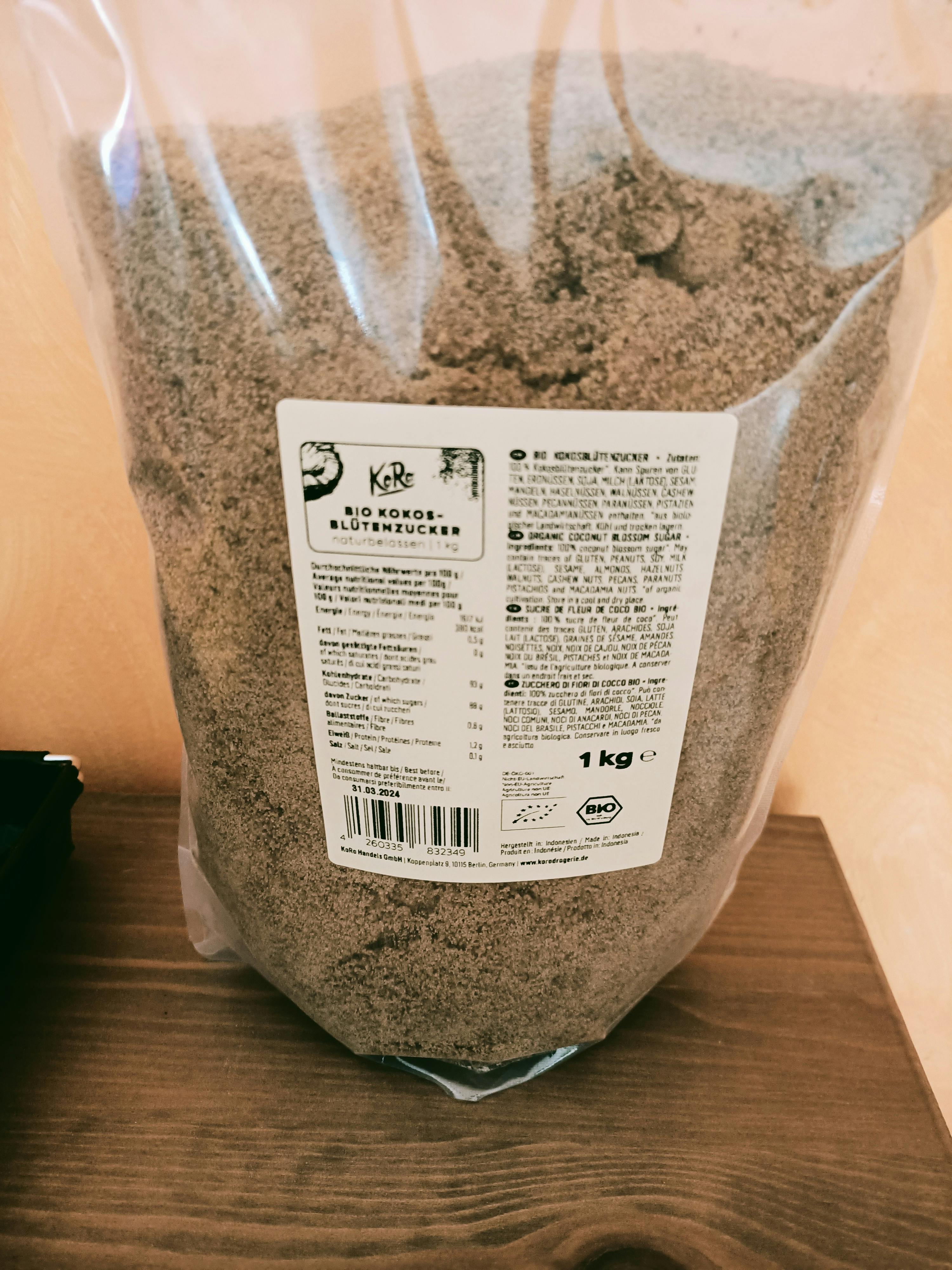un sacchetto di zucchero di cocco bio si trova su un tavolo di legno